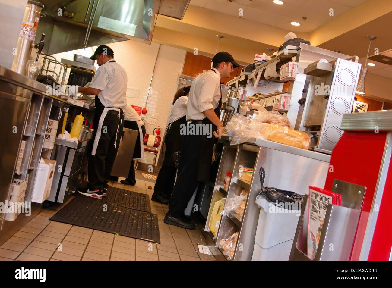 Fairfax, VA USA. Aug 2105. Fast food kitchen meal preparer reading multiple hanging meal checks. Stock Photo