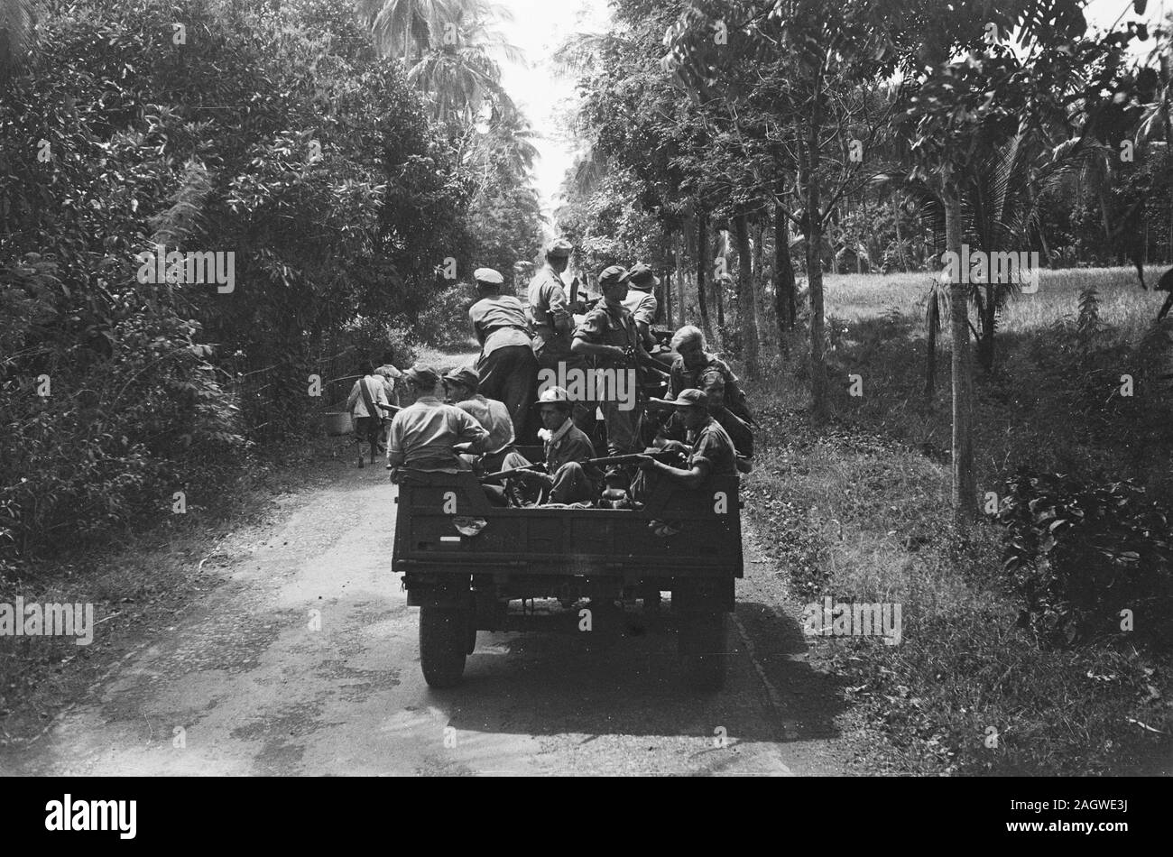 Column of army trucks with infantrymen; Date 1946; Location Indonesia, Dutch East Indies Stock Photo