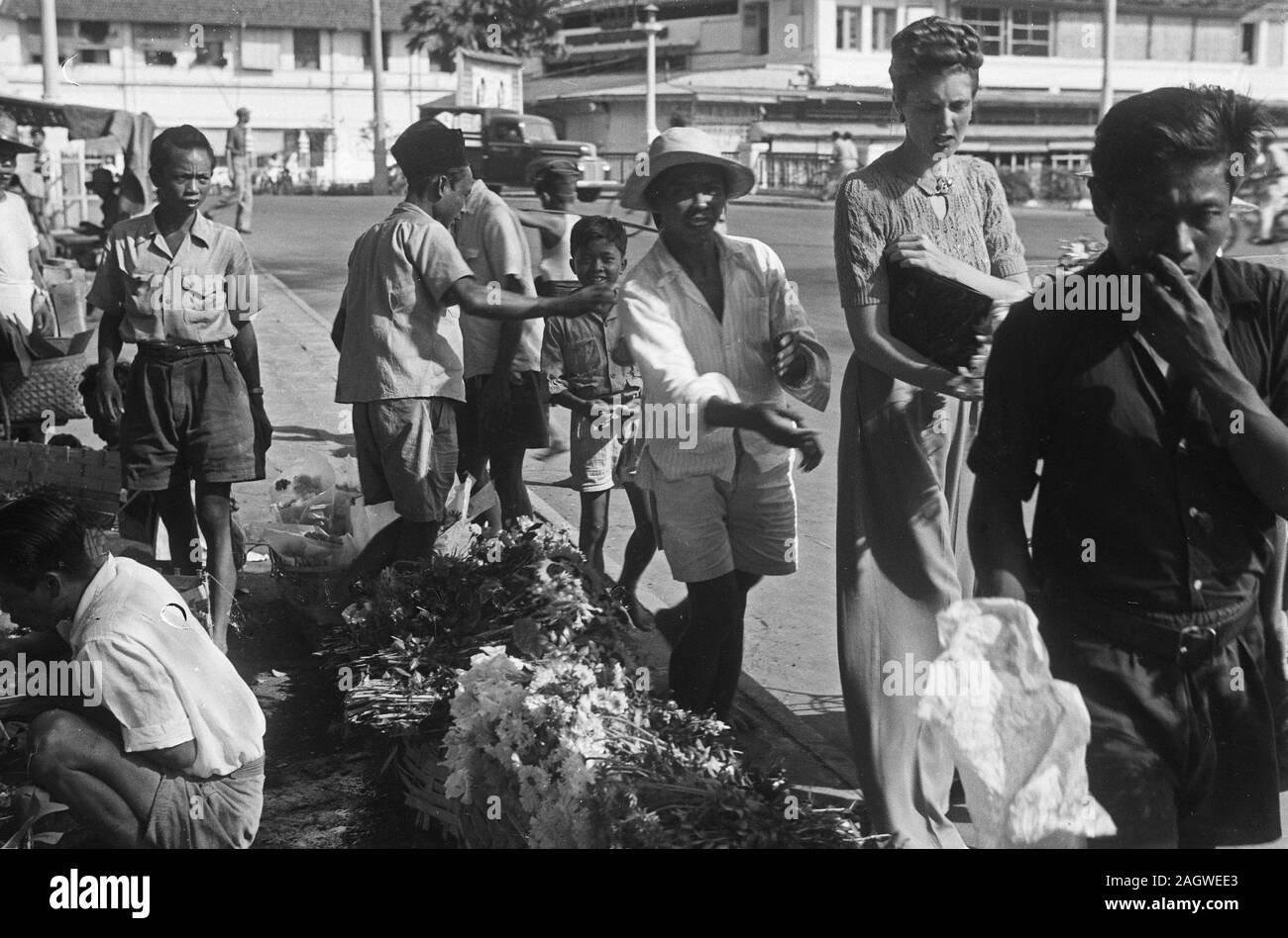 1940s Indonesia - Street scenes. A Dutch woman buys flowers from a florist - 24 August 1948 Stock Photo