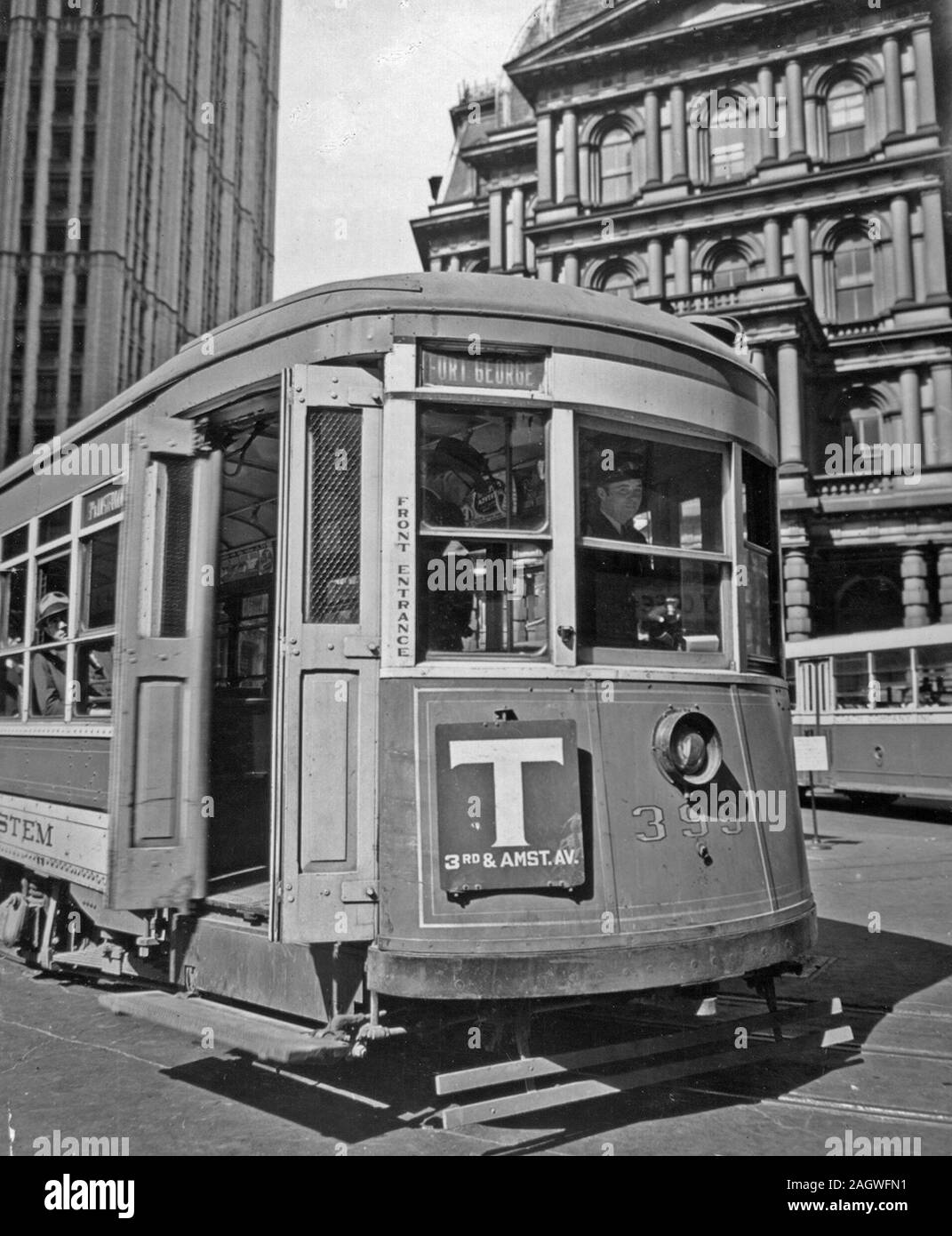 1930s New York City - Third Ave. trolley in front of old Post Office, and Woolworth building, left, driver and riders visible through windows ca. 1938 Stock Photo