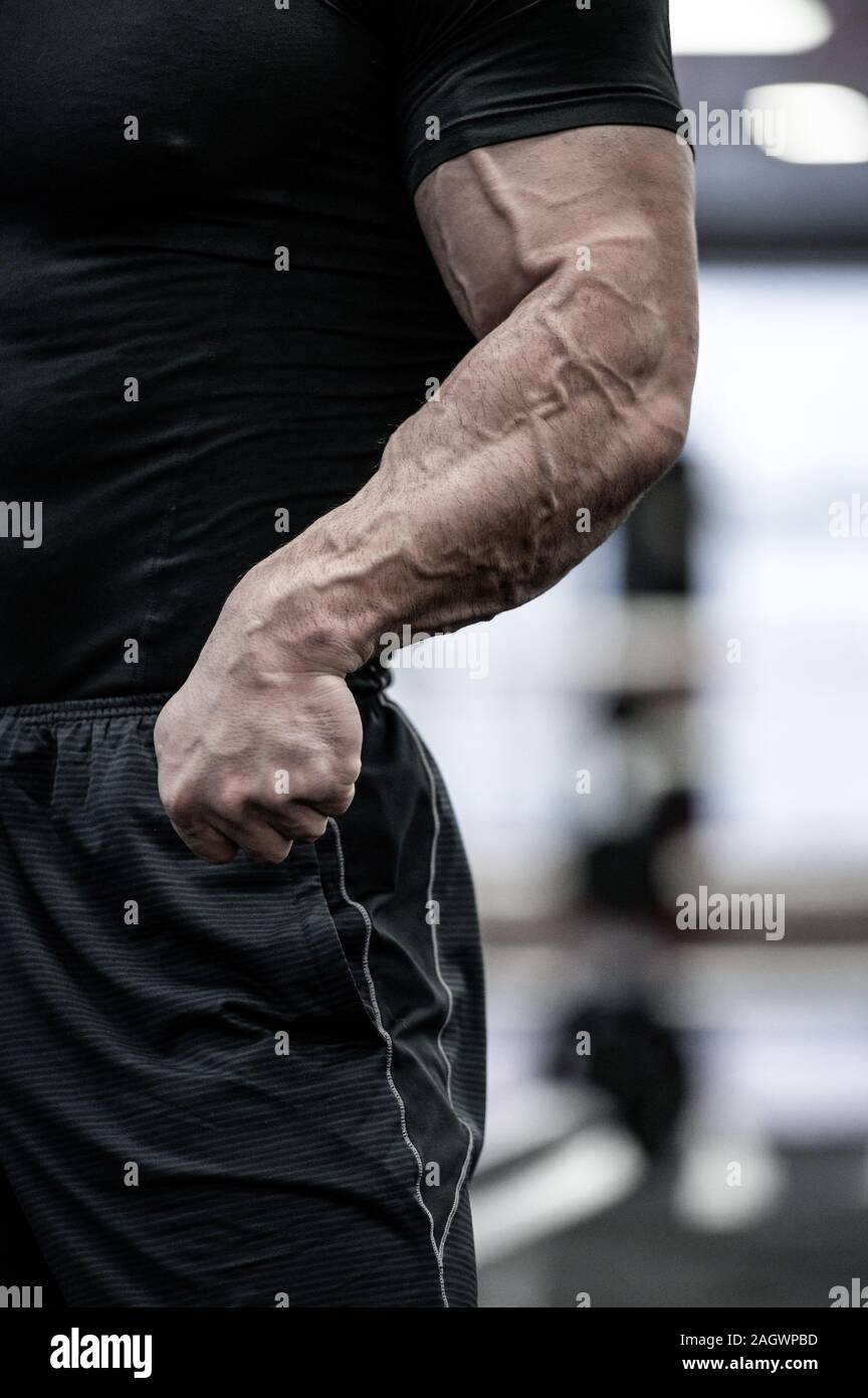 body physique part of strong man in black sportswear showing strong