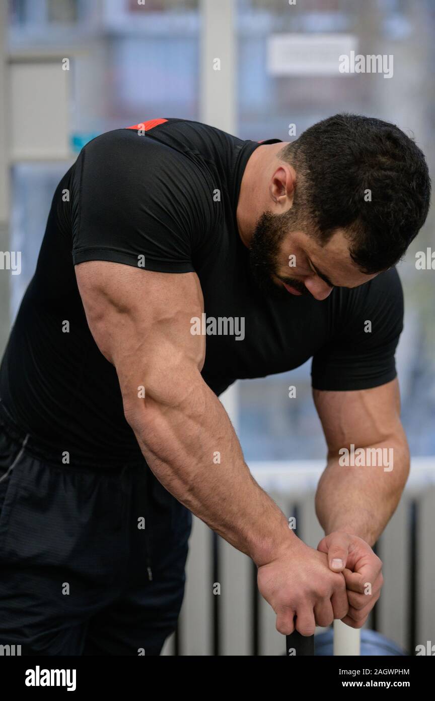 sport mind motivation concept of young strong tired man with beard leaning in gym during workout pause Stock Photo