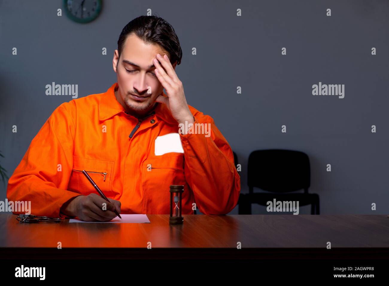 The young convict man sitting in dark room Stock Photo