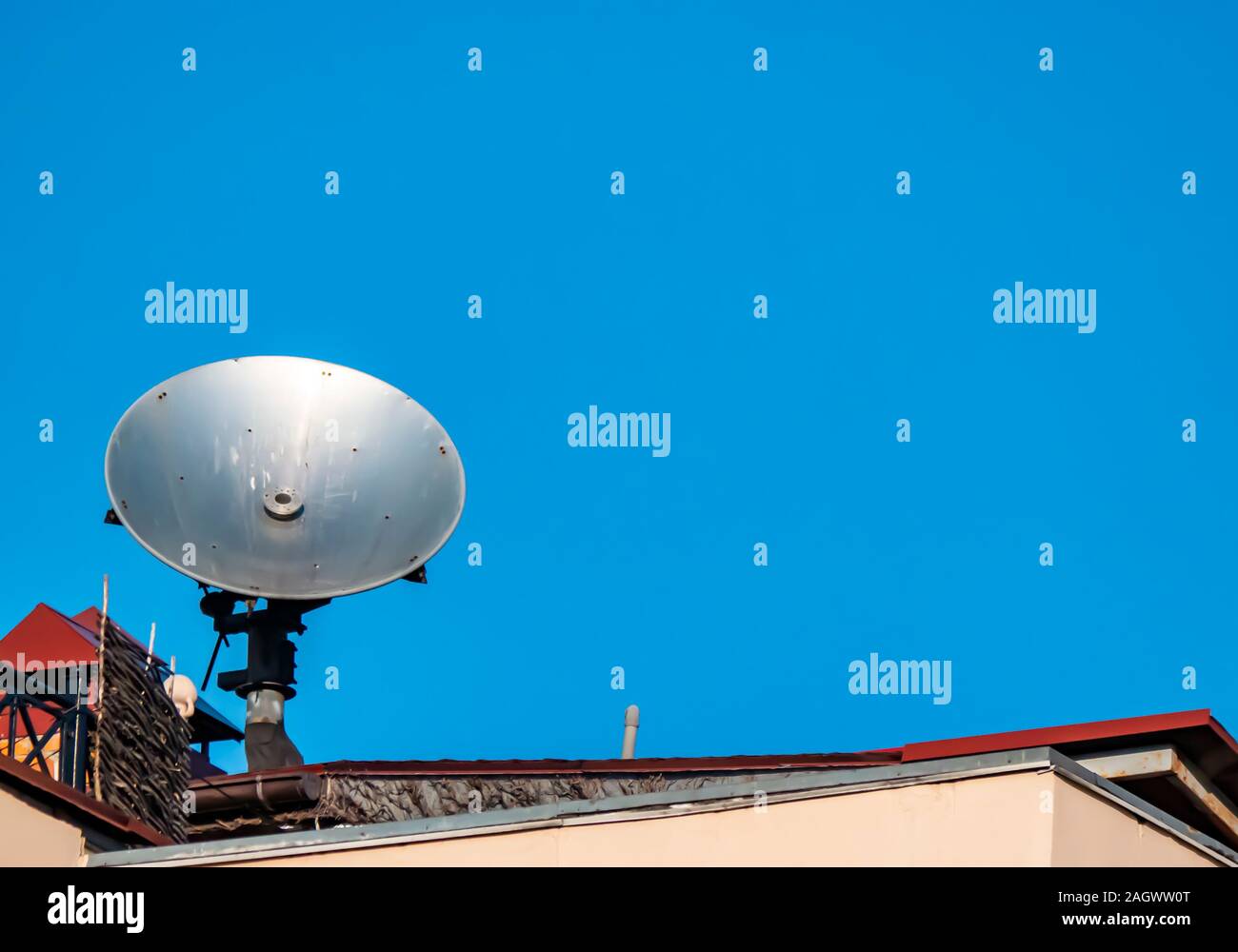 Satellite dish on the roof of the building against the blue sky.  Technology. Place for text. Background image Stock Photo - Alamy