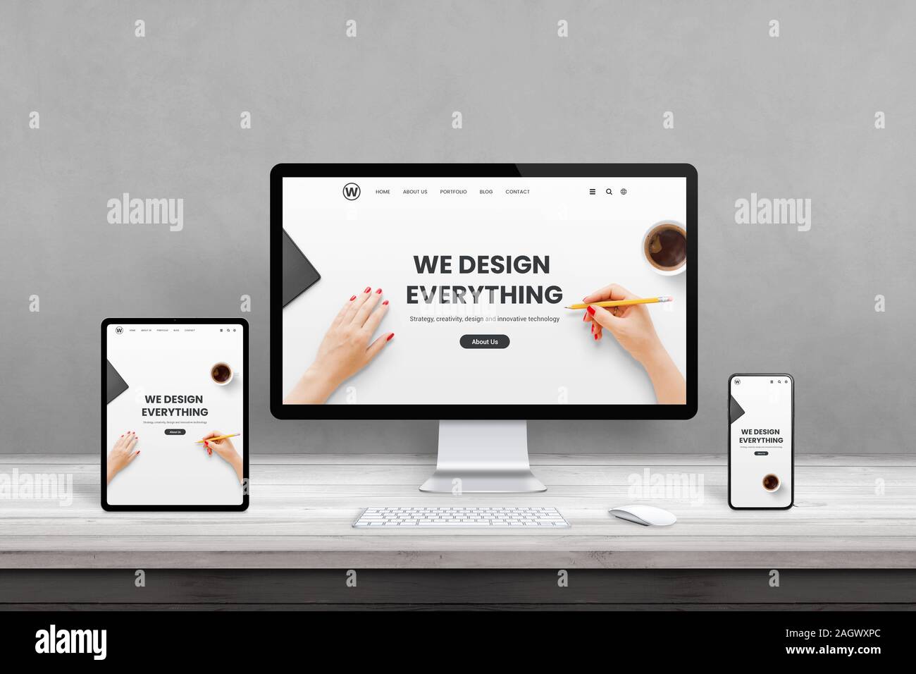 Web design studio with multiple devices on office desk. Concept of responsive, flat web page design. Modern devices with thin edges on wooden desk Stock Photo