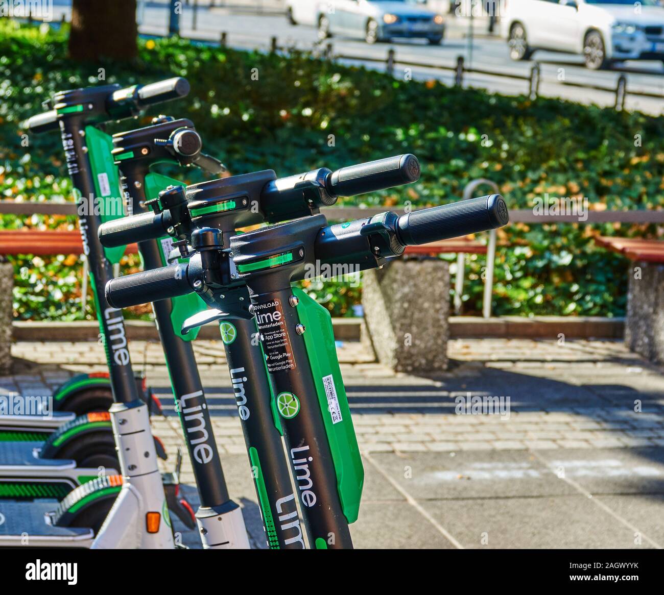 Frankfurt, Germany, October 2., 2019: Parked e-scooters for rent on the sidewalk in front of nenches and plants Stock Photo