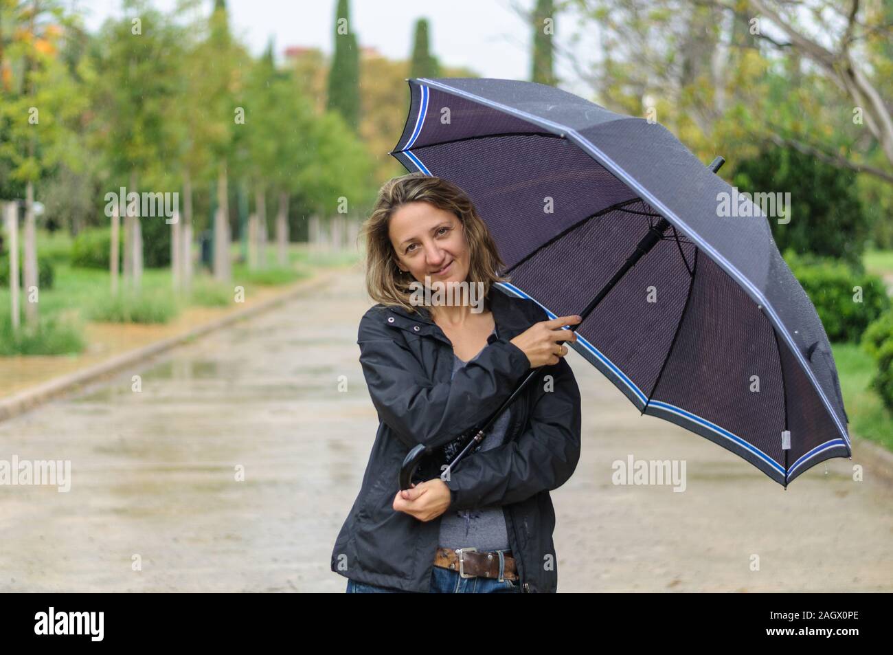 in the city on the street a girl with an umbrella in the rain Stock ...