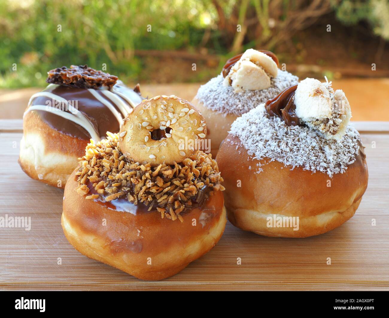 Four delicious donuts with different fillings. Blurred background. Stock Photo