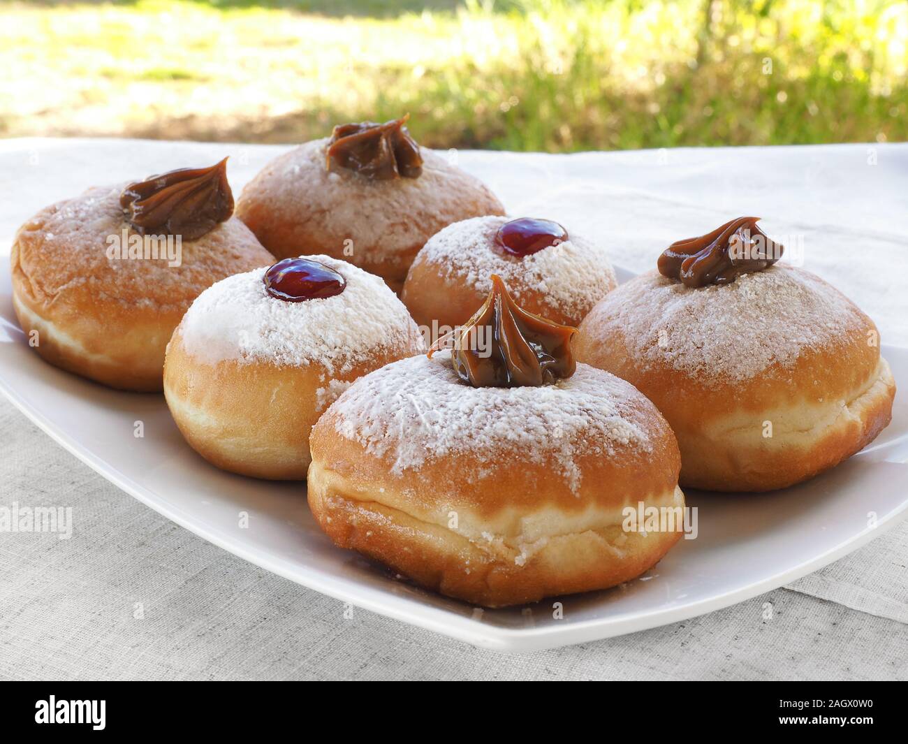 Six delicious Hanukkah donuts with different fillings. Blurred background. Stock Photo