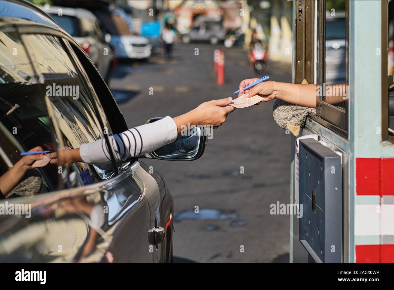 At a checkpost at (market) Pak Klong Talaat (Talad) in Bangkok, Thailand, a motorist buys a parking ticket Stock Photo