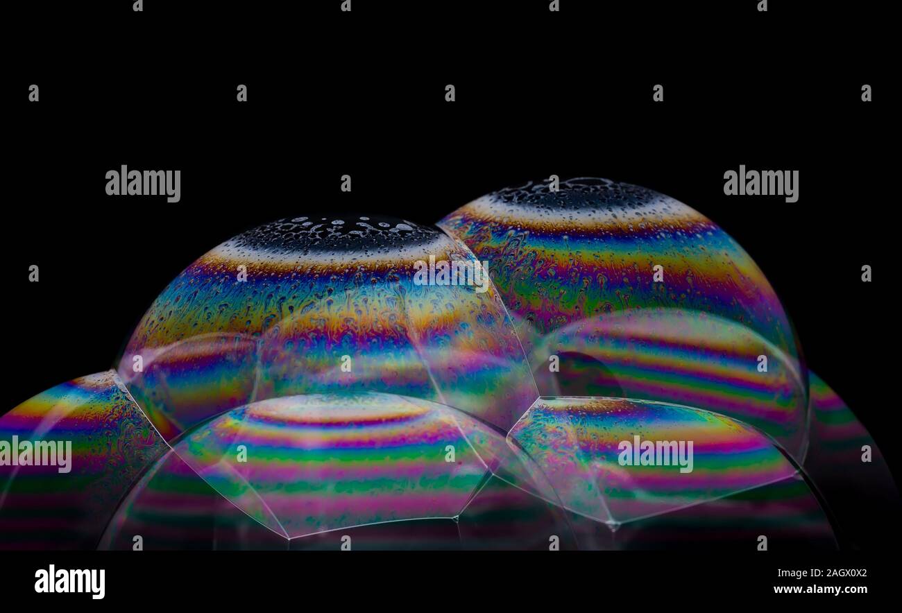 A pile of transparent soap bubbles with an interference pattern on the surface Stock Photo