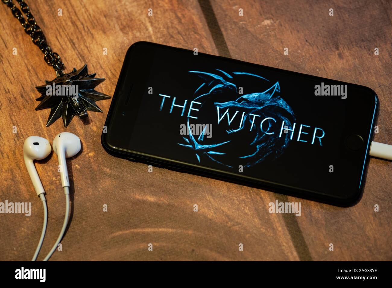 NIZHYN,UKRAINE/21 December 2019: Witcher's medallion and iPhone with logo of new Netflix TV show 'The Witcher' on the screen Stock Photo