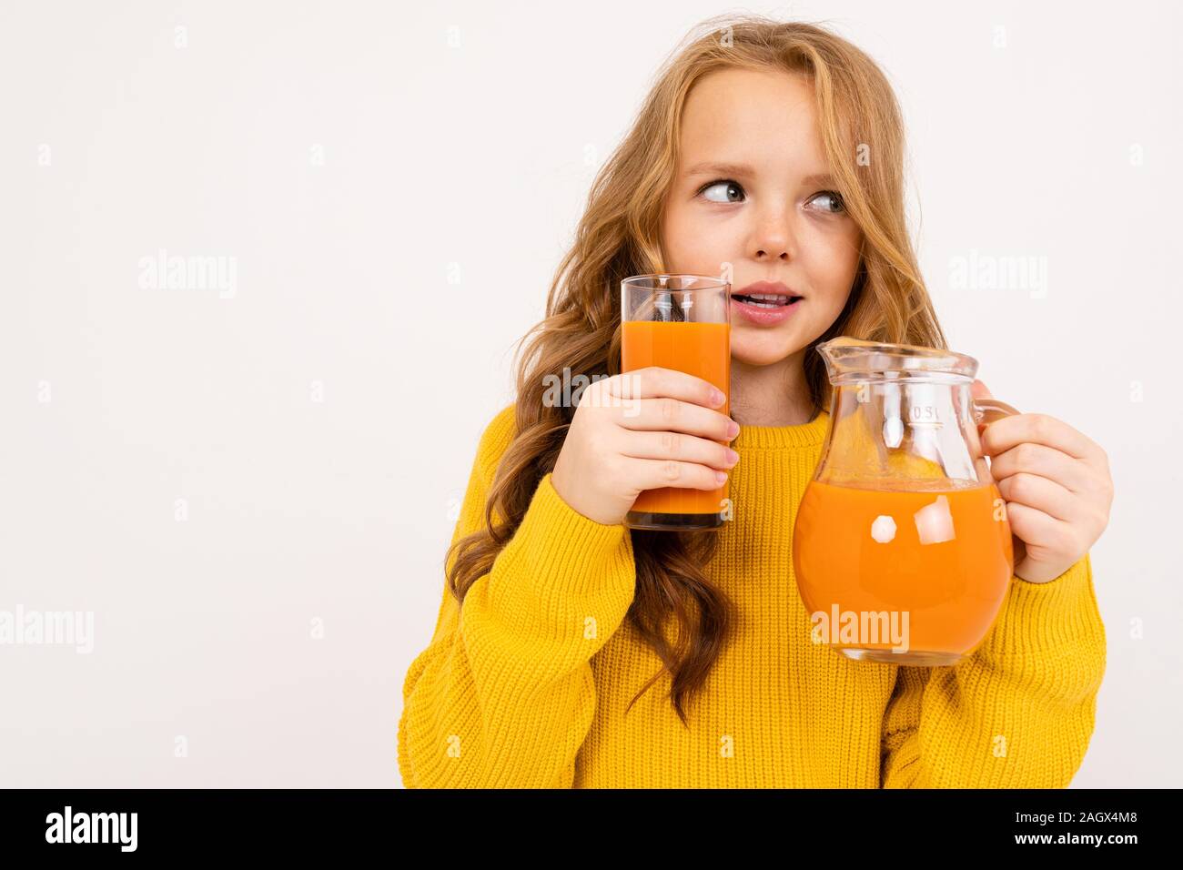 Happy teenager girl with red hair, hoody and yellow trousers drinks carrot juice isolated on white background Stock Photo - Alamy Happy teenager girl with red hair, hoody and yellow trousers drinks carrot juice isolated on white background Stock Photo - Alamy