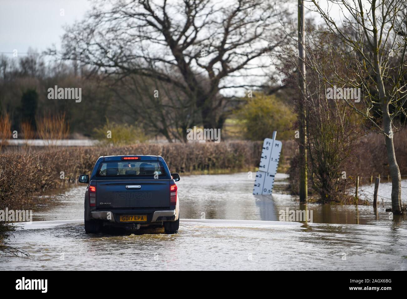 Lewes UK 22nd December 2019 - A car negotiates a flooded road in the village of Barcombe Mills near Lewes as more weather and flood warnings have been issued across Britain after days of rain : Credit Simon Dack / Alamy Live News Stock Photo