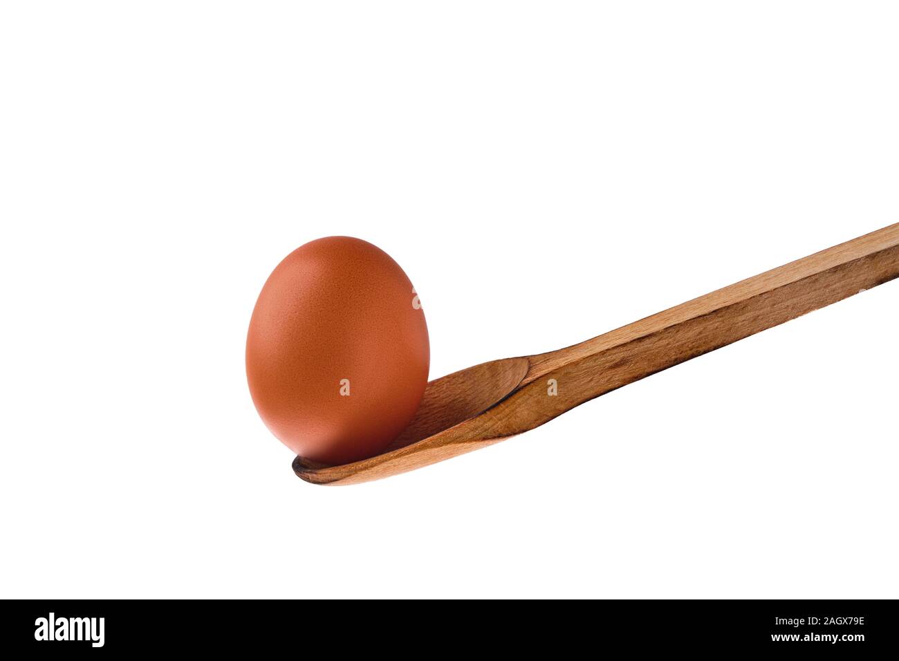 Closeup view of brown chicken egg balancing on wooden spoon isolated on white Stock Photo