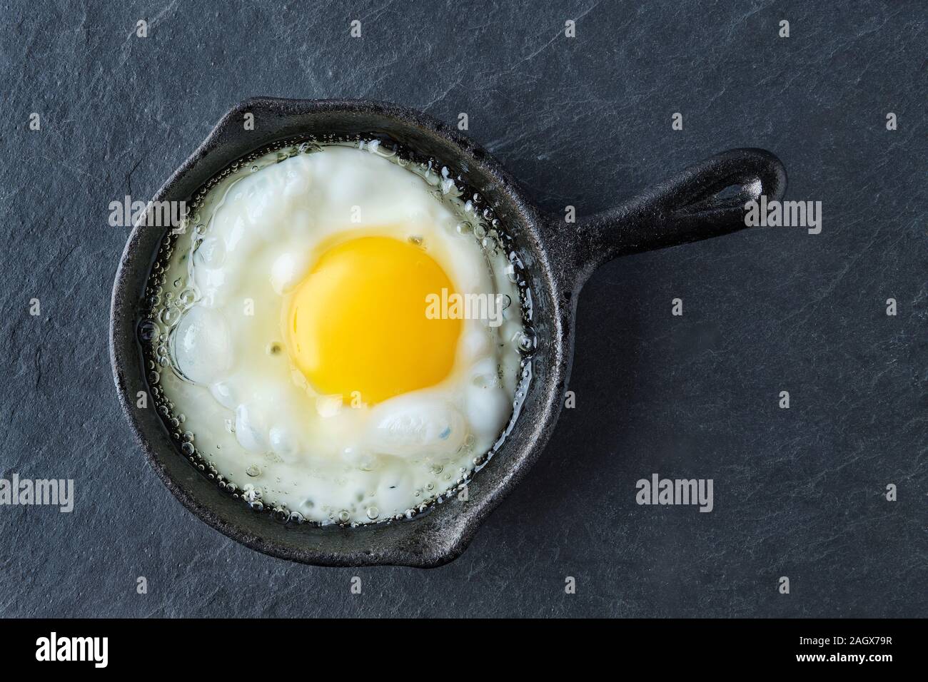 Top view of fried egg in small castiron skillet. Making scrambled eggs