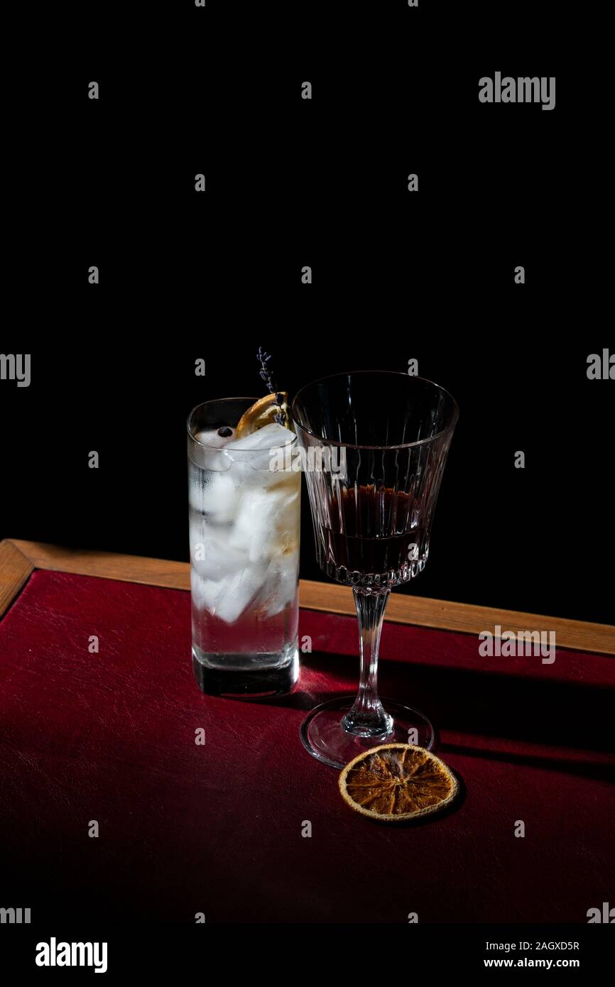 Gin Tonic and red vermouth garnisched with charred orange and lavender