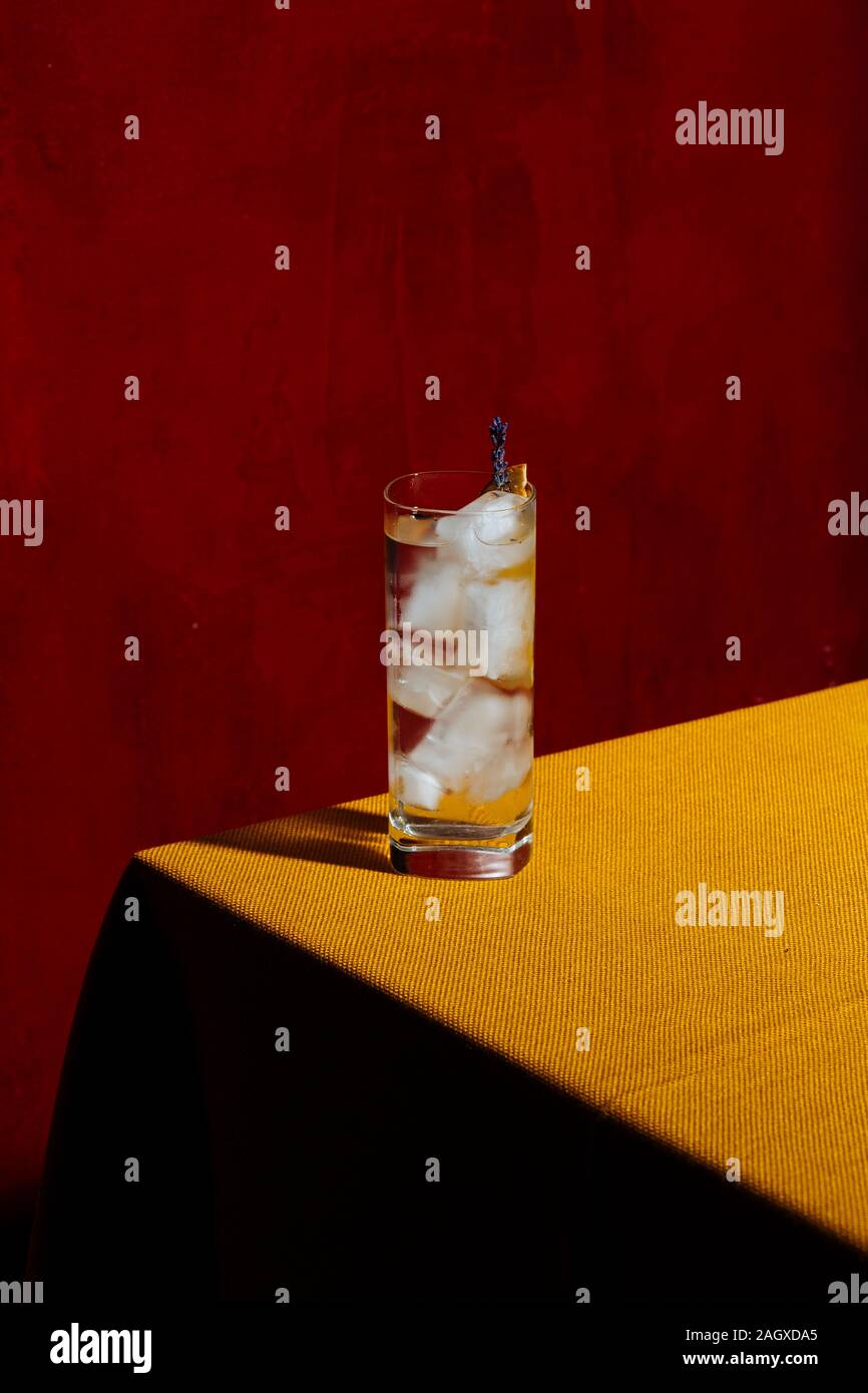 Gin Tonic garnisched with charred orange and lavender ,a long drink with gin and tonic water. Colorful background Stock Photo