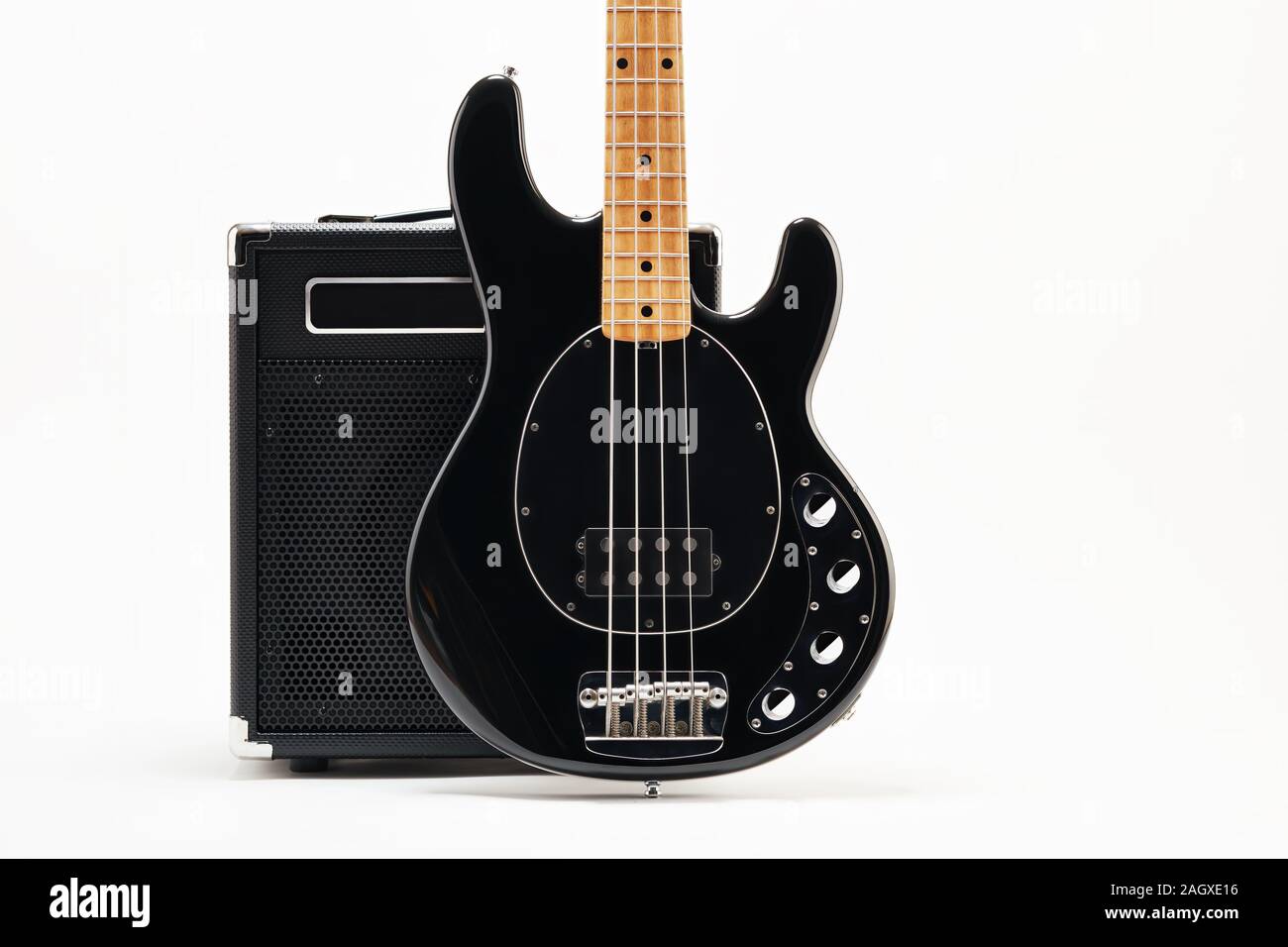 Vintage black electric bass guitar and amplifier on white background