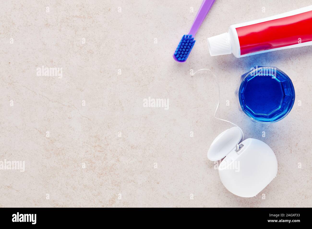Toothbrush, toothpaste, dental floss and mouthwash on marble bathroom