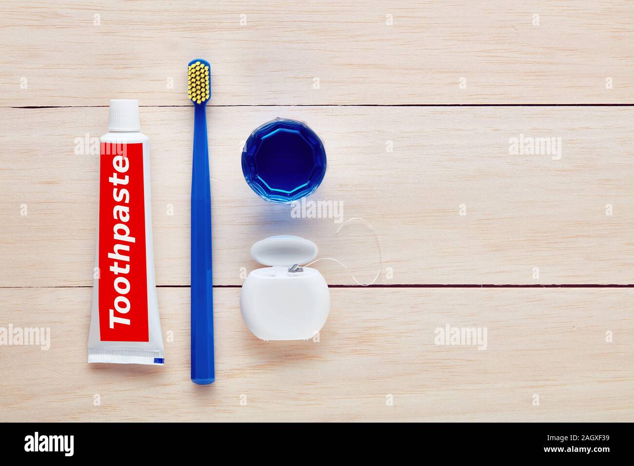 Toothbrush, toothpaste, dental floss and mouthwash on wooden table