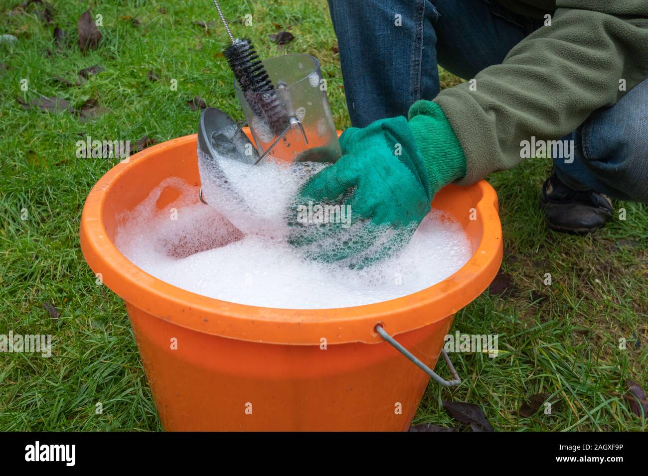 Cleaning a bird feeder or feeders with soapy water and a brush Stock Photo