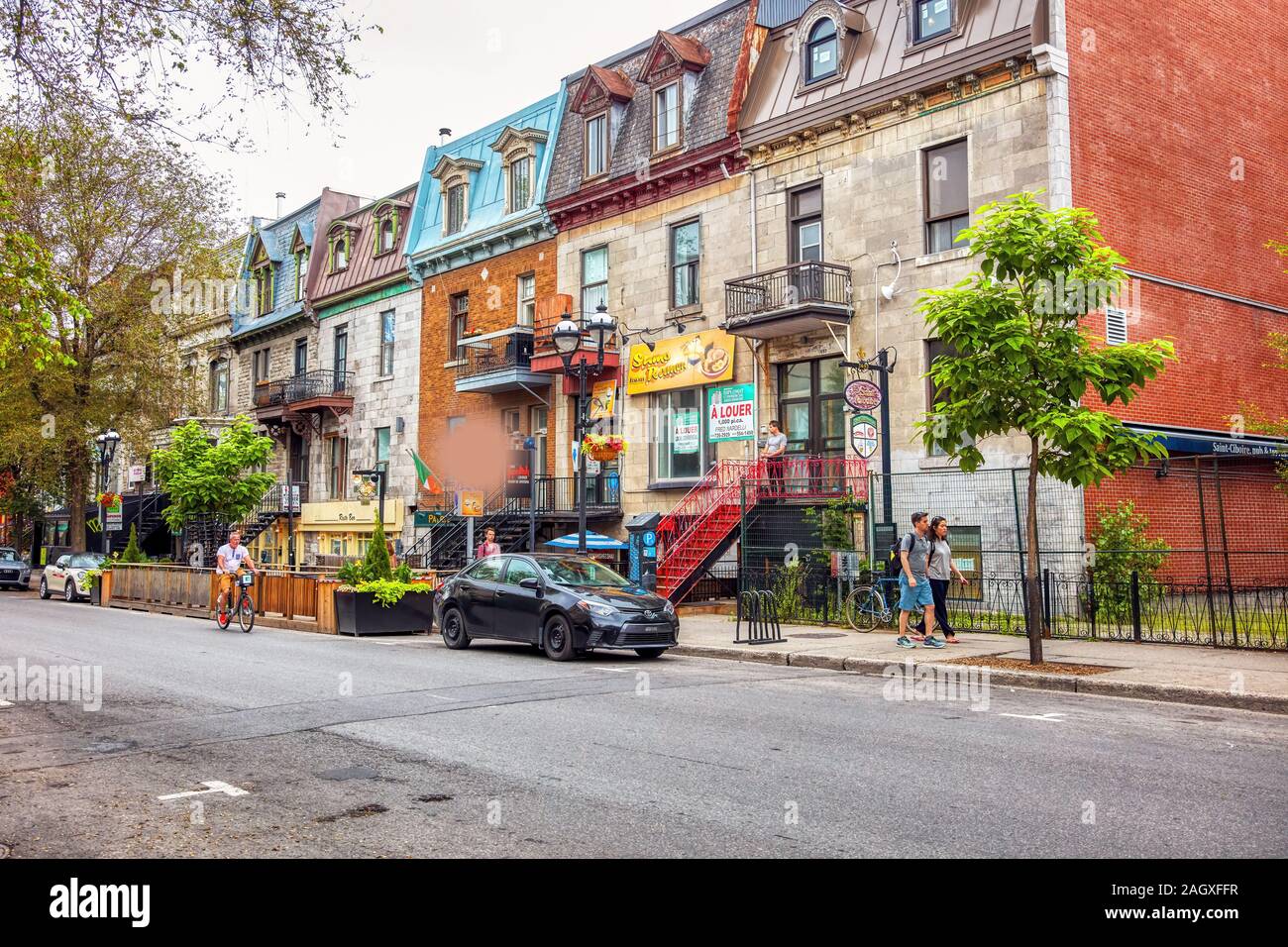Montreal, Canada - June, 2018: People and Victorian houses on famous landmark Saint Denis street in Montreal, Quebec, Canada. Stock Photo