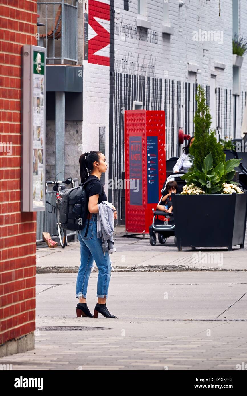 Montreal, Canada June, 2018 Young Asian girl is standing or waiting