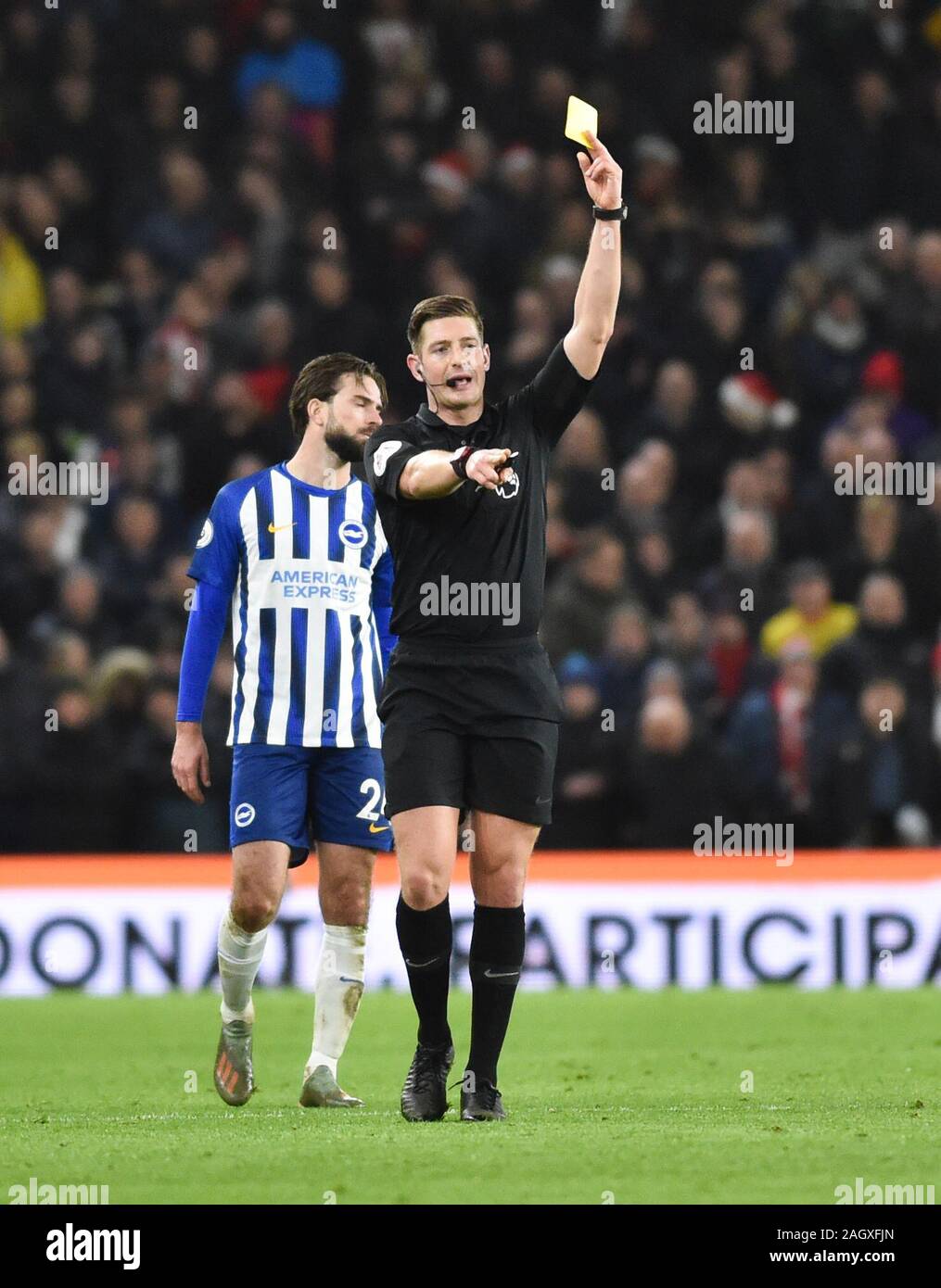 Referee Robert Jones hands out a yellow card during the Premier League match between Brighton and Hove Albion and Sheffield United at The Amex Stadium Brighton, UK - 21st December 2019 - Editorial use only. No merchandising. For Football images FA and Premier League restrictions apply inc. no internet/mobile usage without FAPL license - for details contact Football Dataco Stock Photo