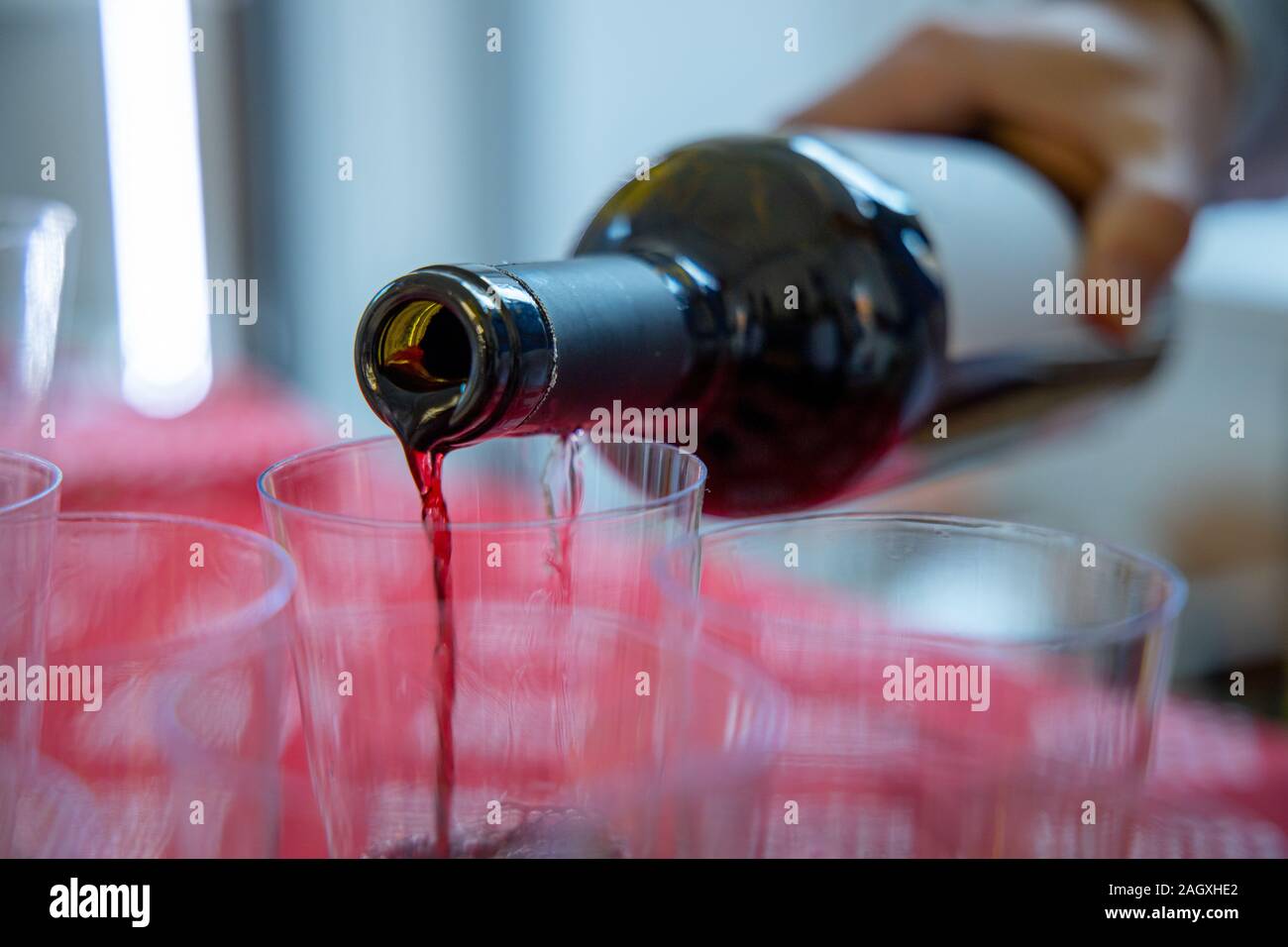 Man pouring red wine into glasses Stock Photo