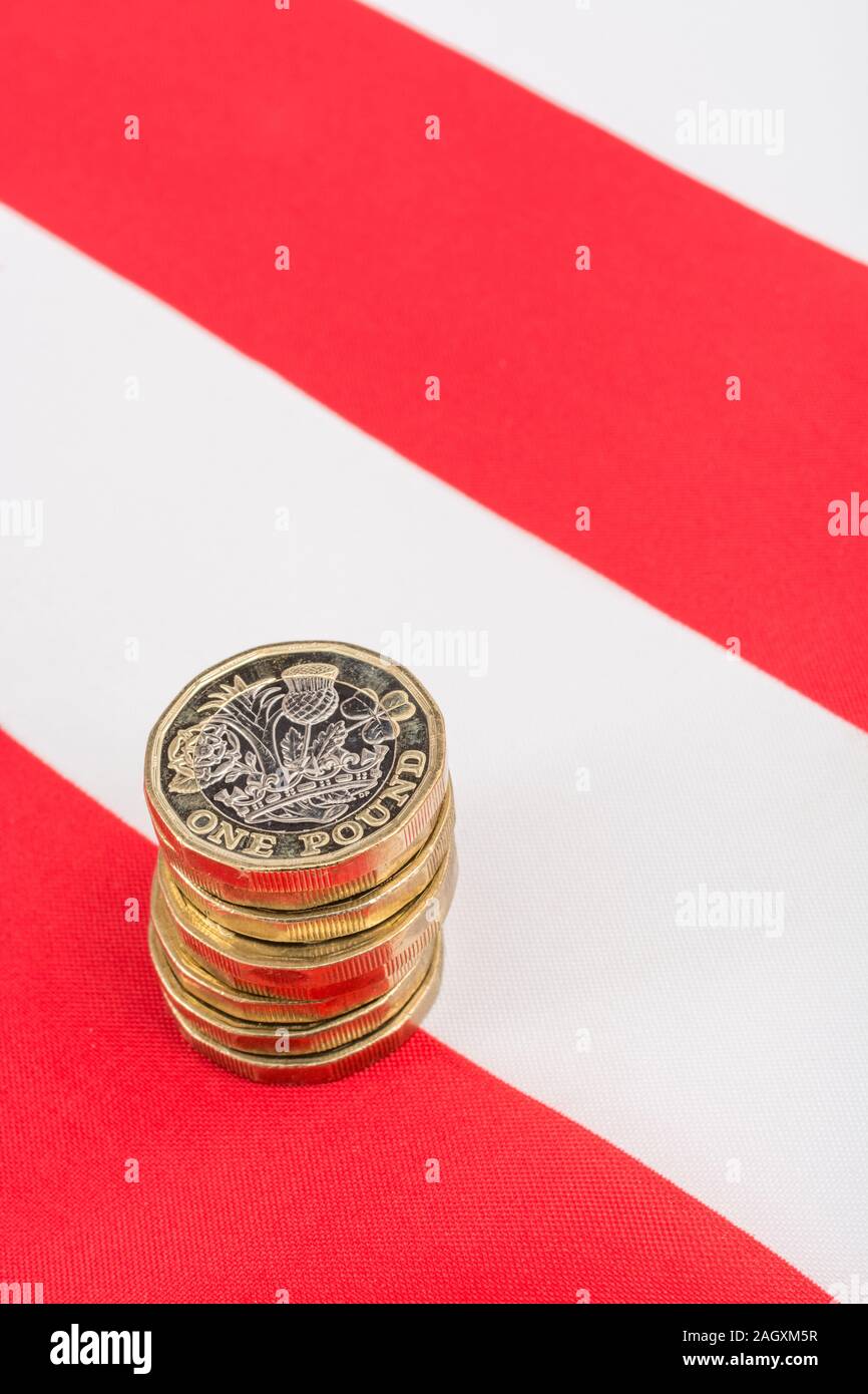 Stacked £1 coins on American Stars & Stripes flag. Metaphor US-UK trade deal post Brexit, Sterling exchange rate, Dollar value of Pound, UK exports US Stock Photo