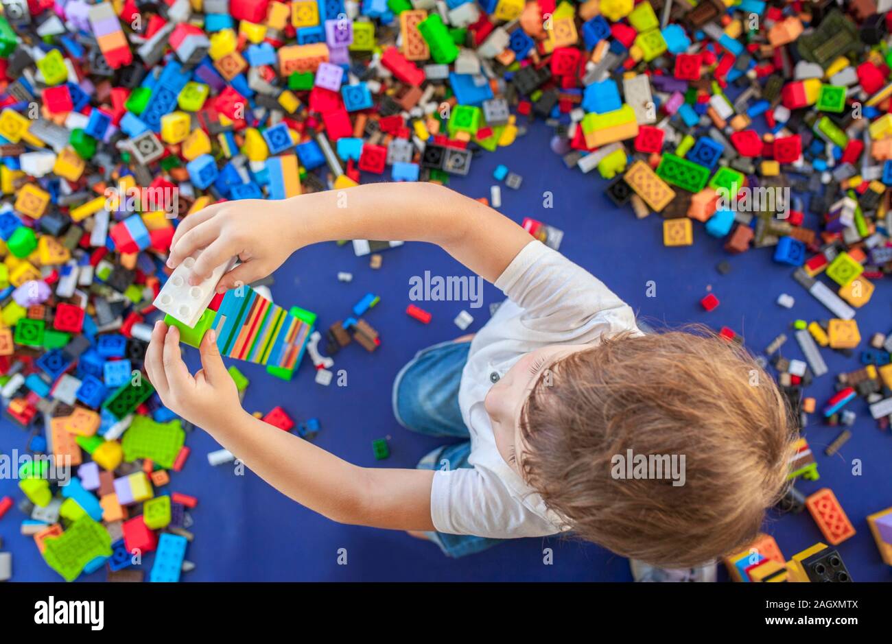4 years boy building a tower with with interlocking plastic bricks. Selective focus Stock Photo