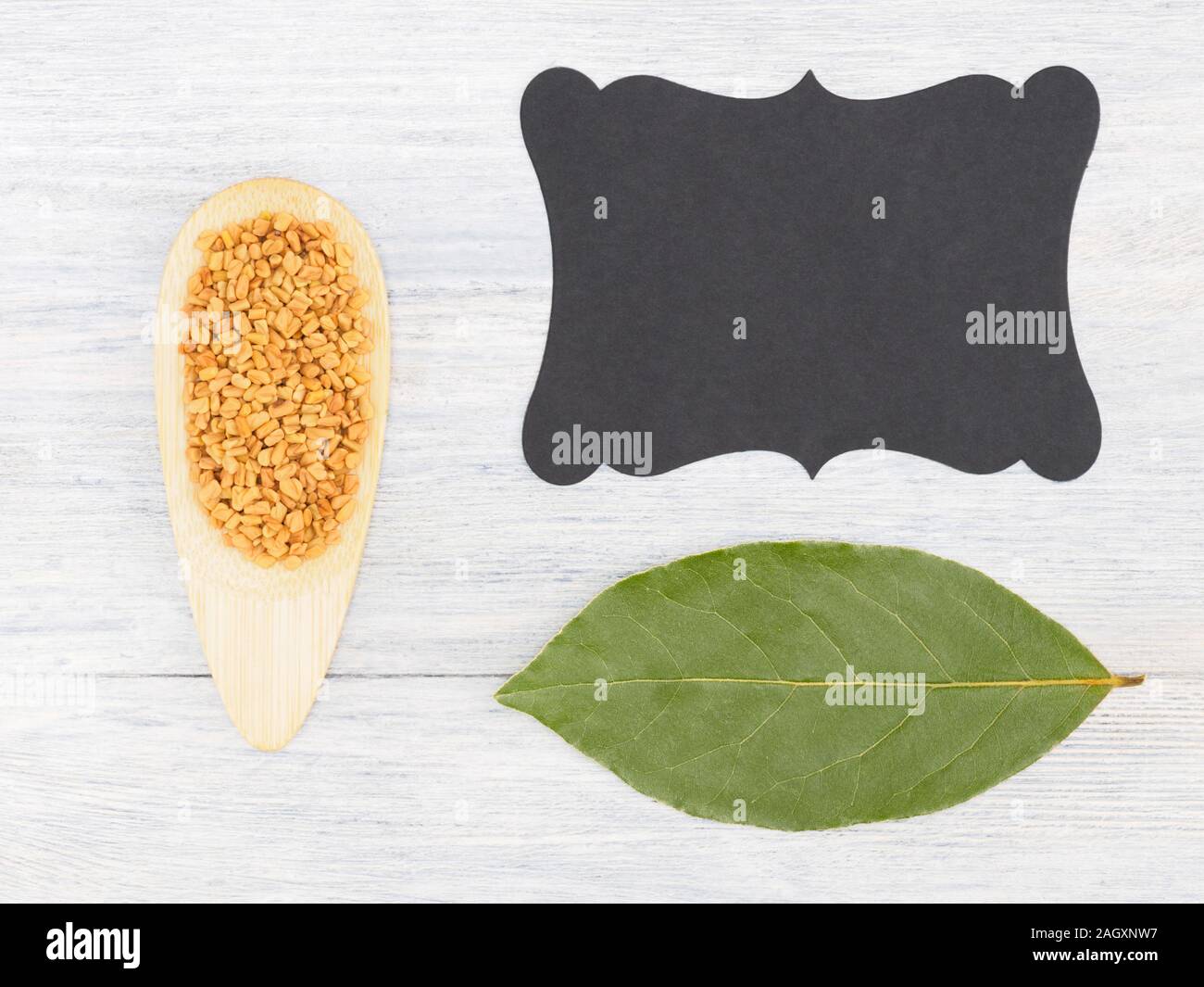 Fenugreek, bay leaf, nameplate on a white concrete background with copy