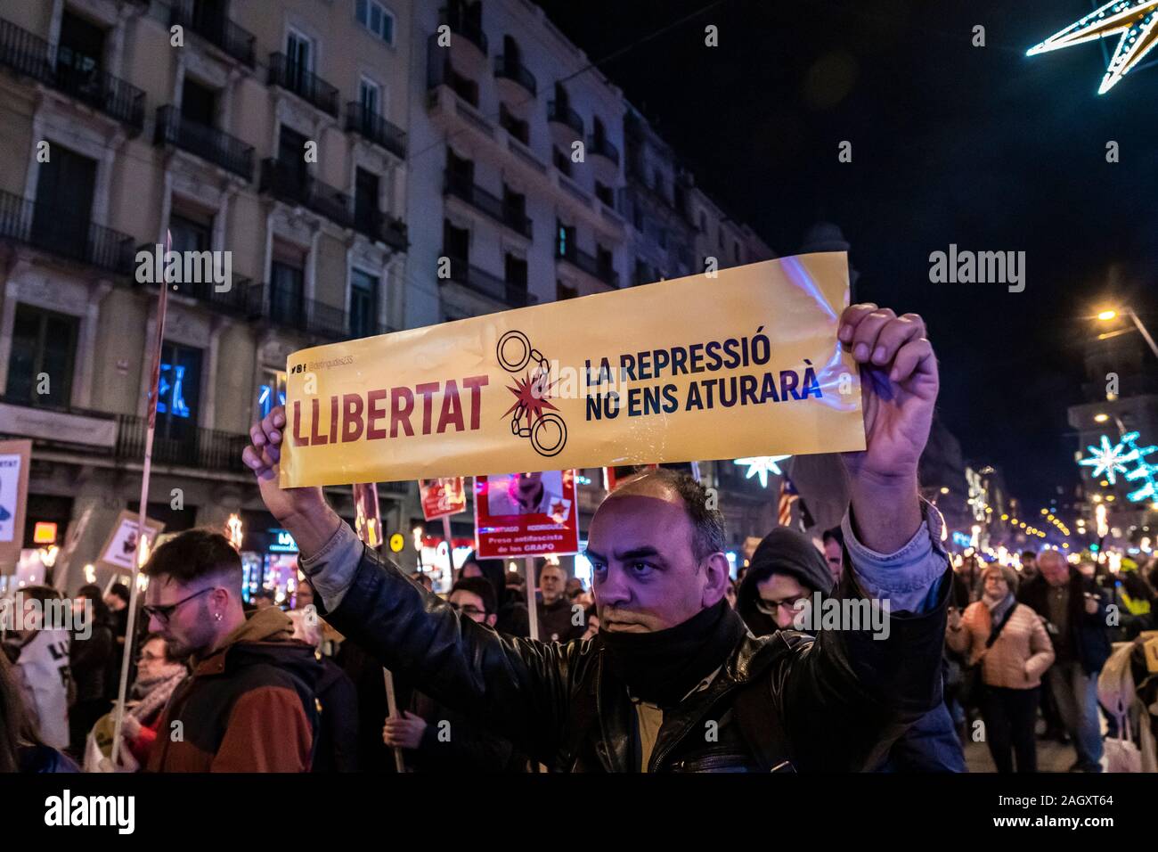 A protester holds a placard during the demonstration.Hundreds of supporters for the independence of Catalonia marched carrying torches lit to demand for freedom of the political prisoners convicted of sedition and embezzlement of public funds to long prison sentences. Stock Photo
