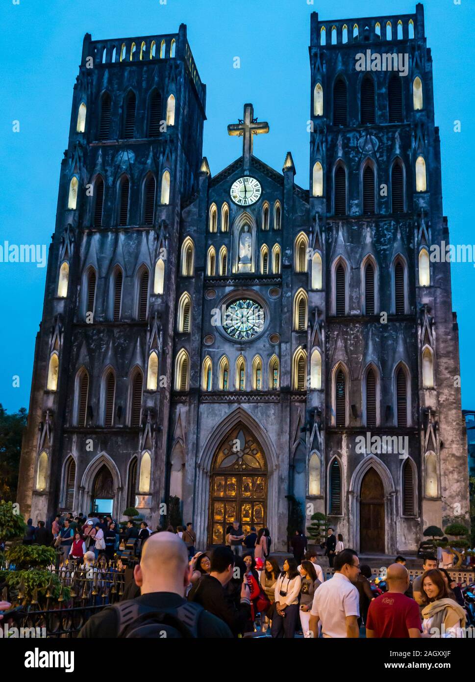 People at St Joseph's Cathedral lit up at dusk, Church Street, Hoan Kiem District, Hanoi, Vietnam, Southeast Asia Stock Photo