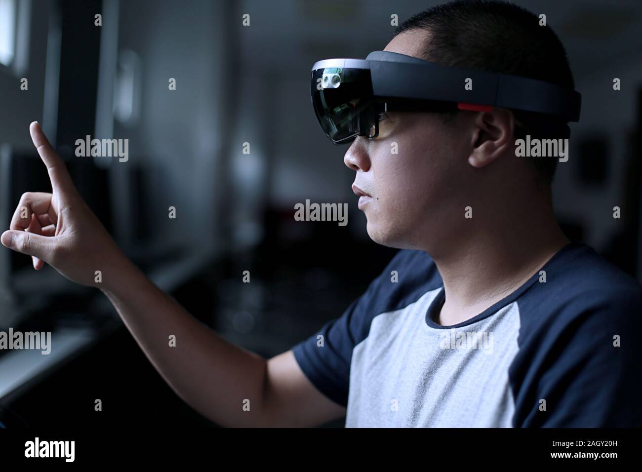 Young asian student trying Mixed reality with VR glasses in the laboratory. Gesture of men when using Virtual Reality headset. Stock Photo