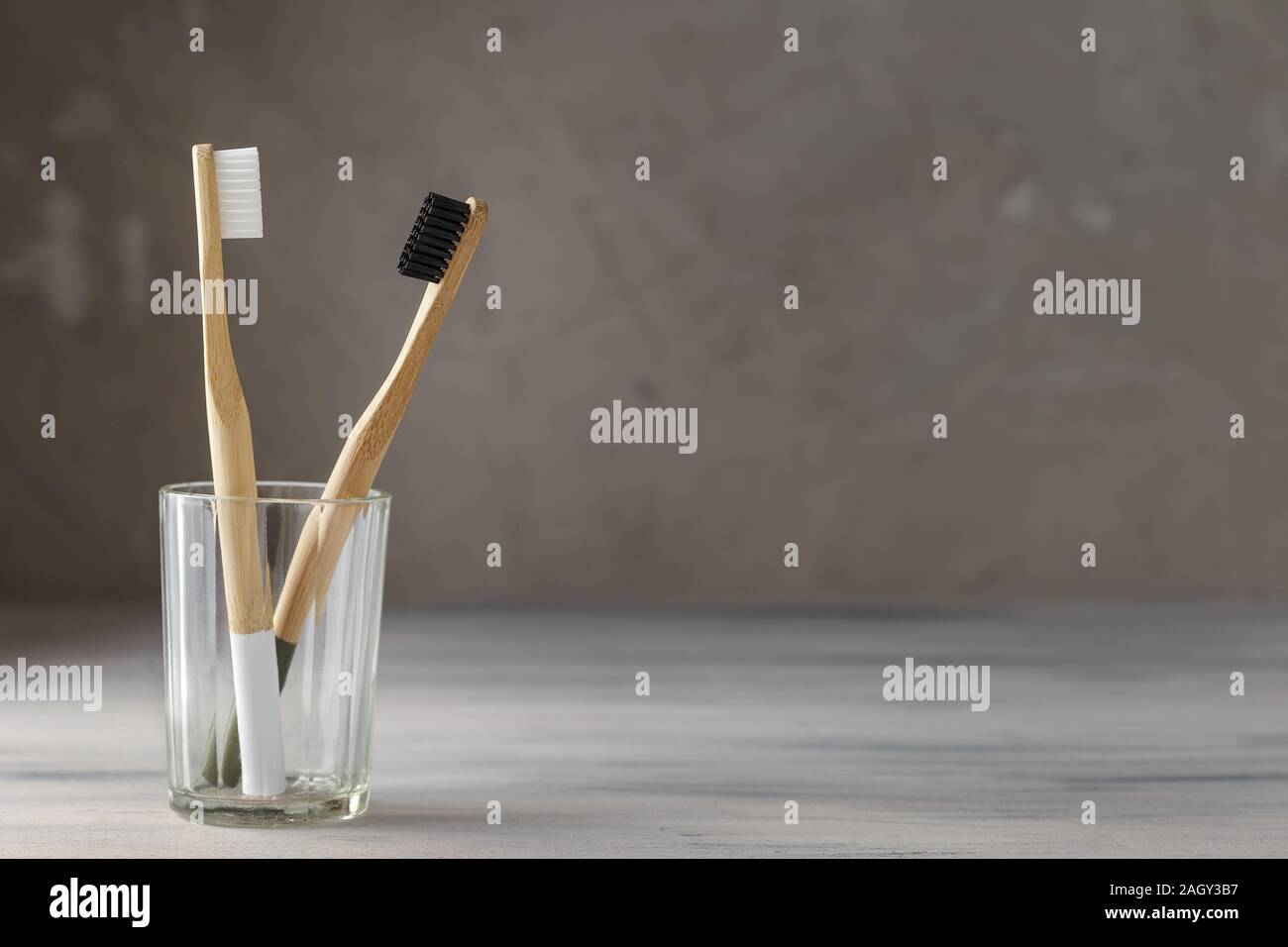 Two eco friendly bamboo tooth brushes in a glass. Zero Waste concept ...