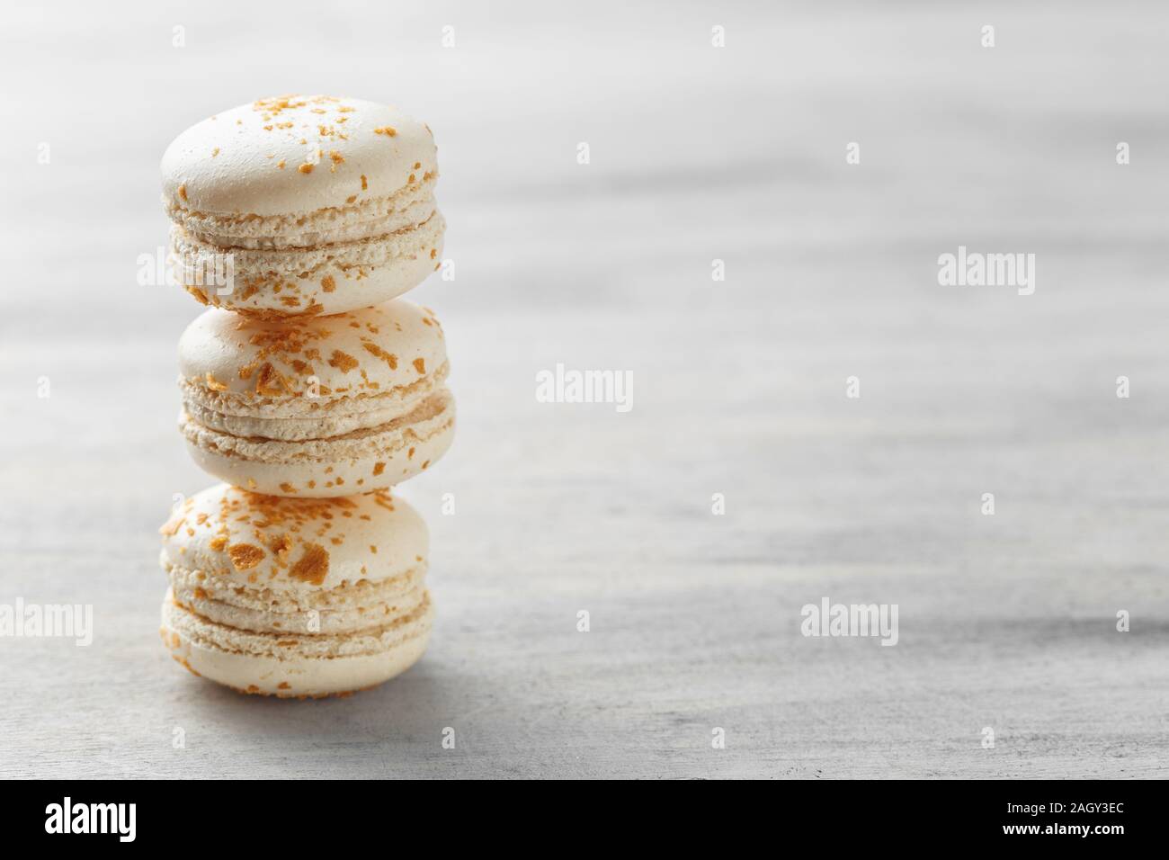 French macarons. Stack of white praline macaroons on grey background. Copy space Stock Photo