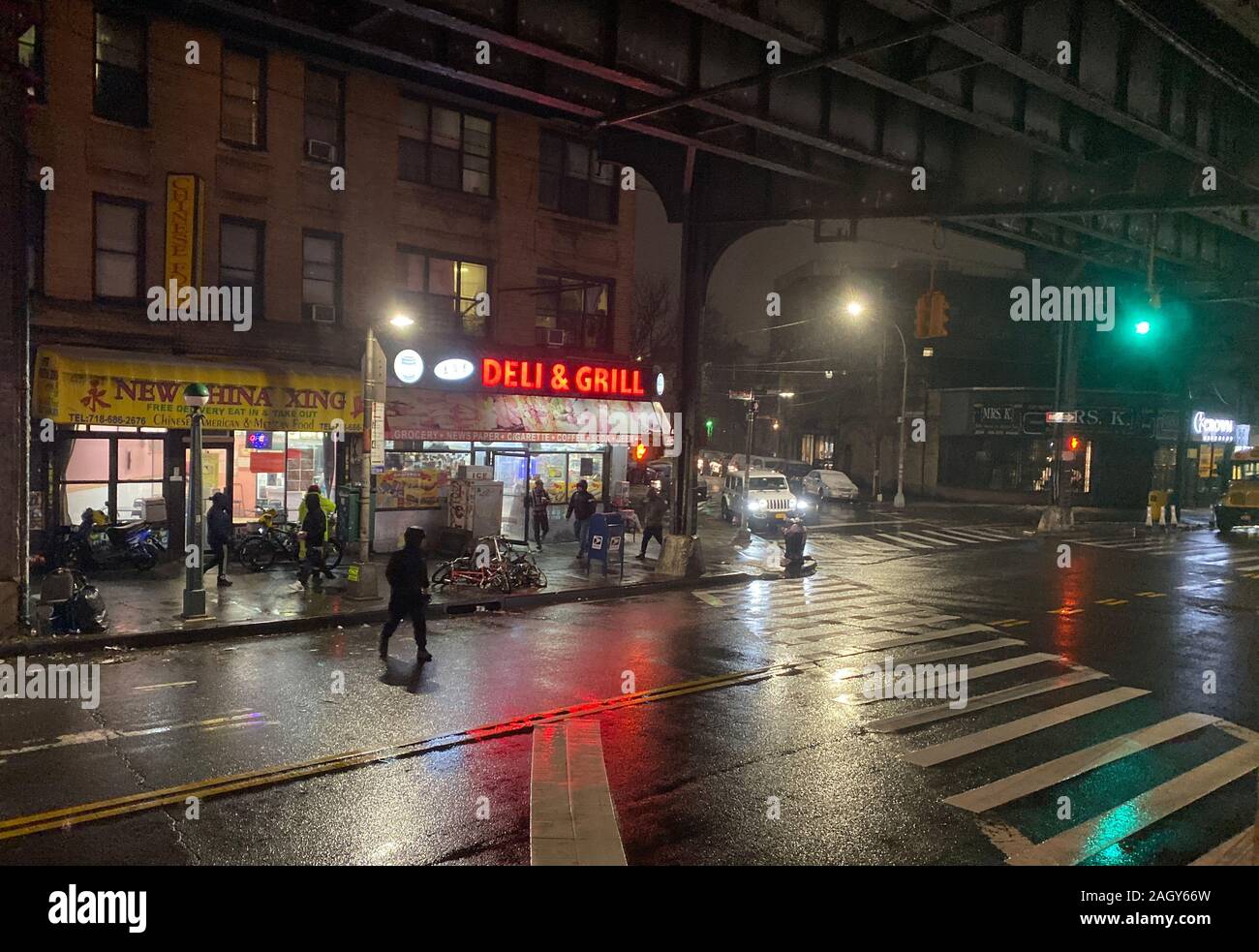 Rainy night under the elevated subway tracks on New Utrecht Avenue in the Borough Park neighborhood of Brooklyn, New York. Stock Photo
