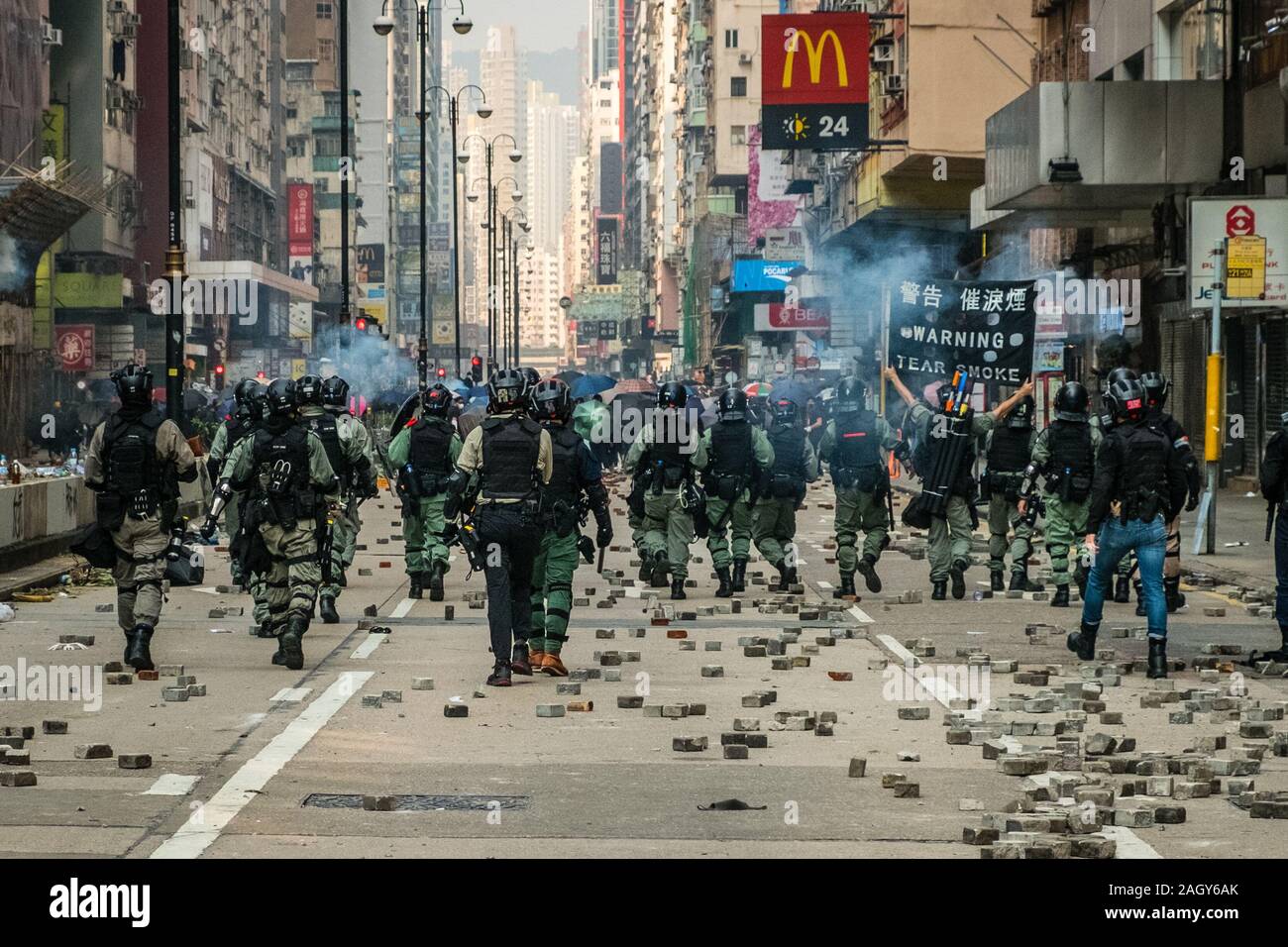 HongKong - November, 2019:  Hong Kong riot police shoot tear gas on protesters on Nathan Road during 2019 HongKong protests Stock Photo