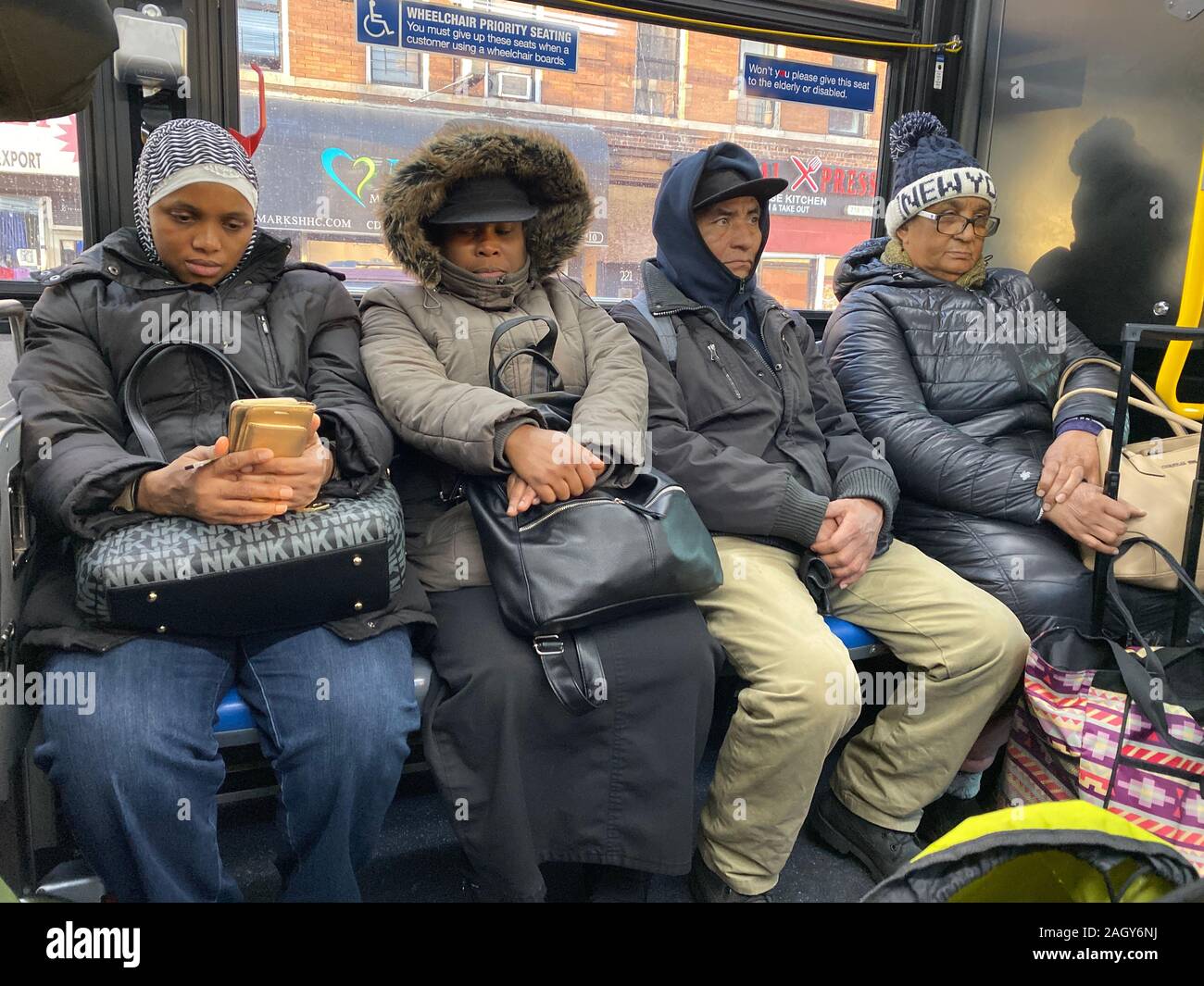 People ride a New York City MTA bus in Brooklyn, New York on a cold