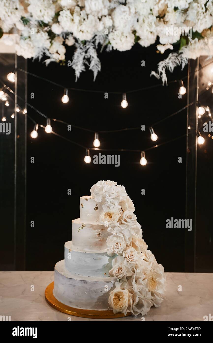 White Wedding Cake With Peonies And Roses Flowers On The Night