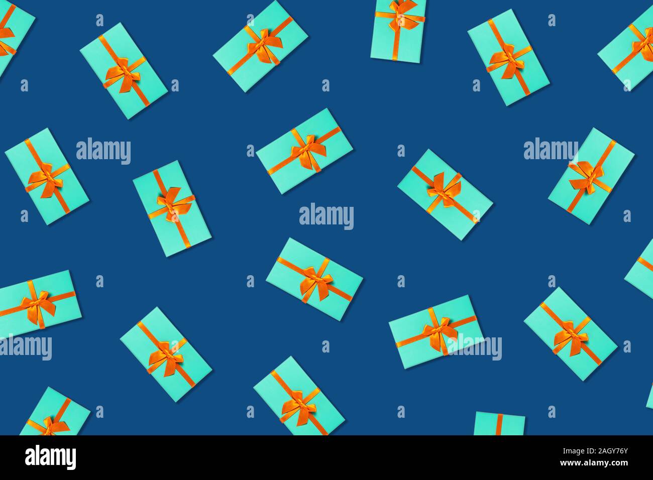 Orange bow on a mint boxes located on classic blue background. Stock Photo