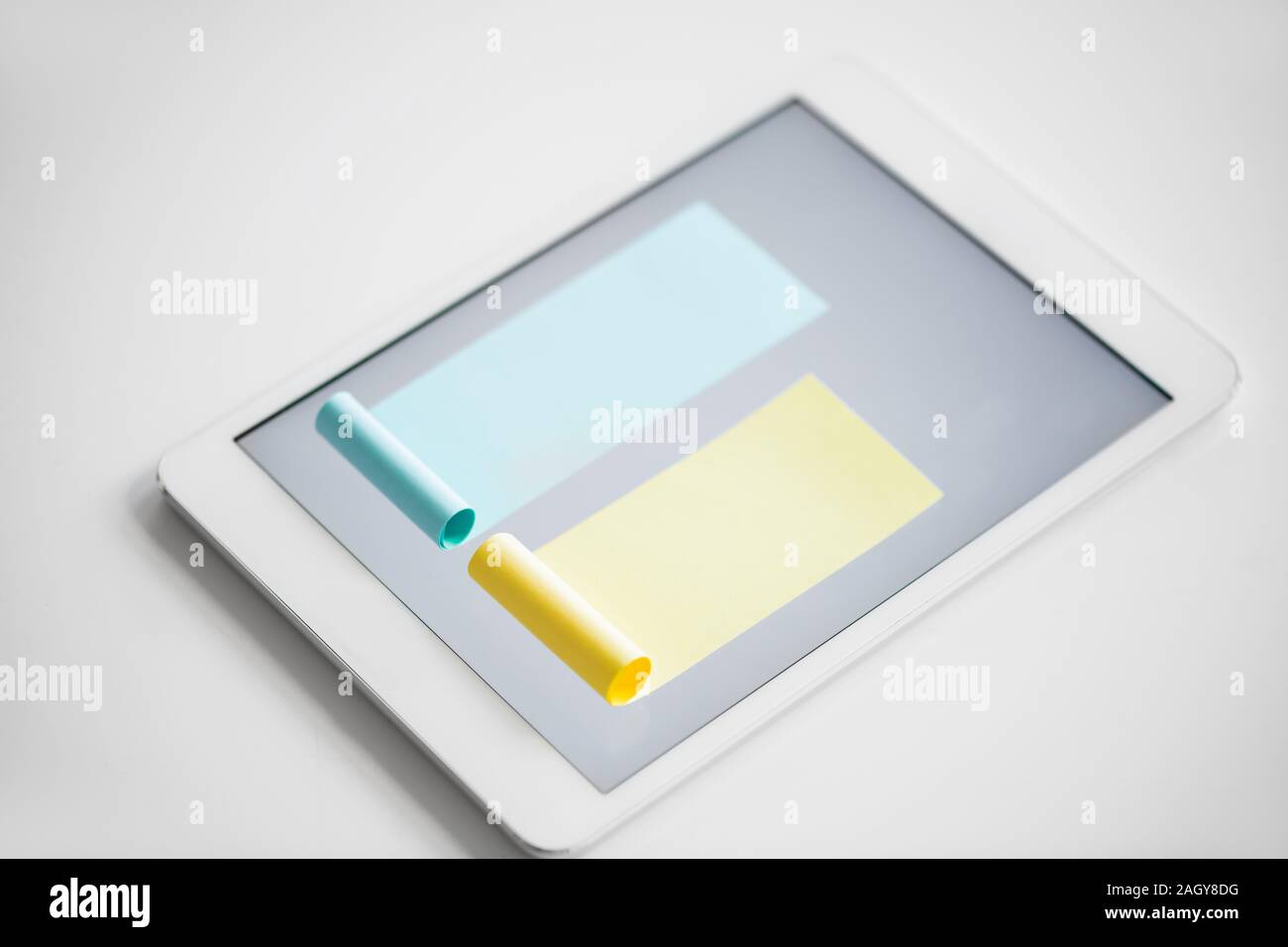 Chart made up of blue and smaller yellow notepapers stuck on screen of tablet Stock Photo