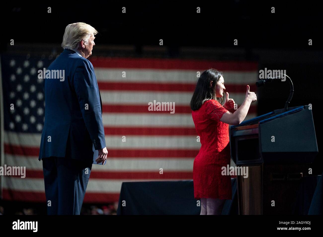 U.S President Donald Trump watches as Binghamton University student Lacey Kecheter gives thumbs-up during her address at the Turning Point USA 5th annual Student Action Summit at the Palm Beach County Convention Center December 21, 2019 in West Palm Beach, Florida. Trump rallied the youth conservative group with wild claims on wind turbines and attacks on his opponents. Stock Photo