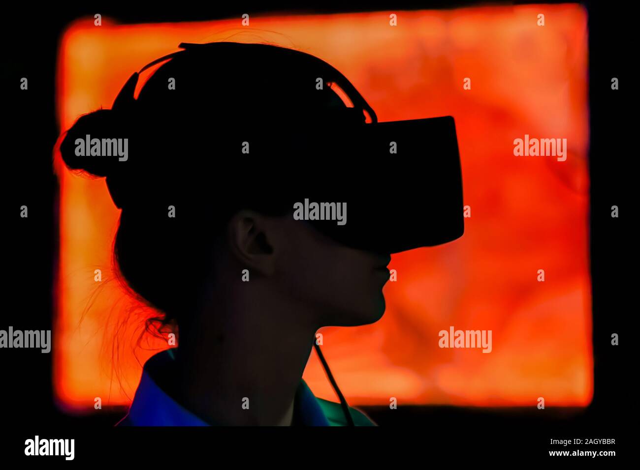 Young woman using virtual reality headset at dark interactive exhibition Stock Photo