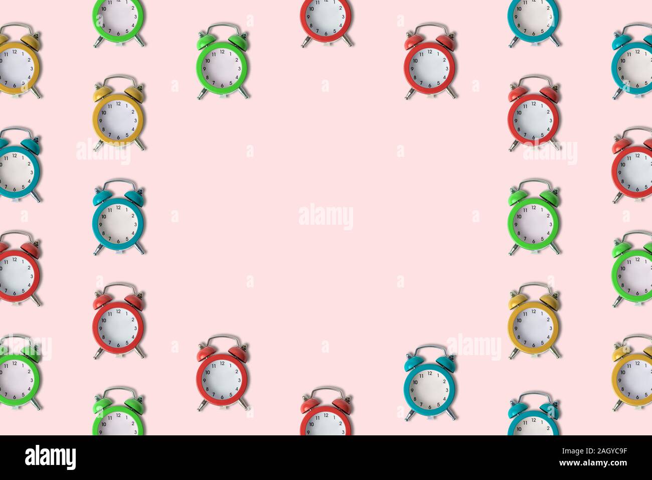 Small colorful alarm clocks without hands pattern minimal creative no time concept. Space for copy. Stock Photo