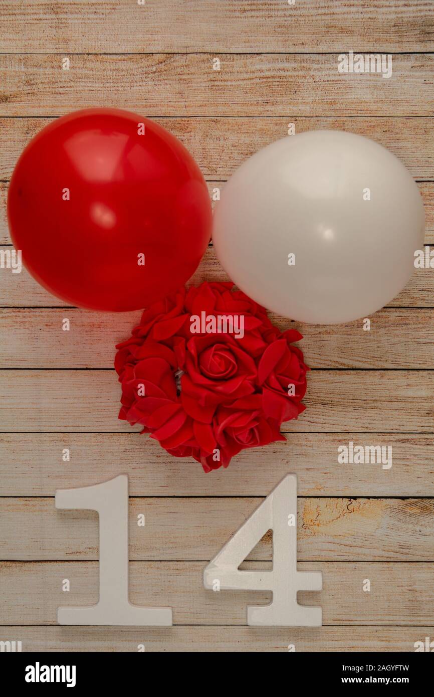 Wooden background with hearts, flowers, balloons and wooden numbers of dated 14 February. The concept of Valentine Day. Top view with space for your g Stock Photo