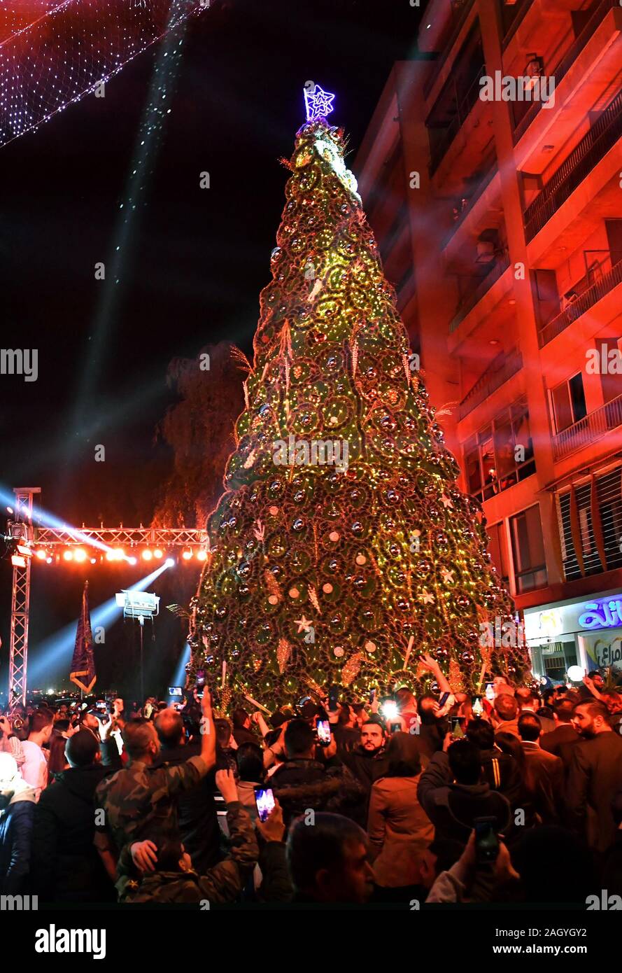 Damascus, Syria. 22nd Dec, 2019. Syrians gather around a Christmas tree