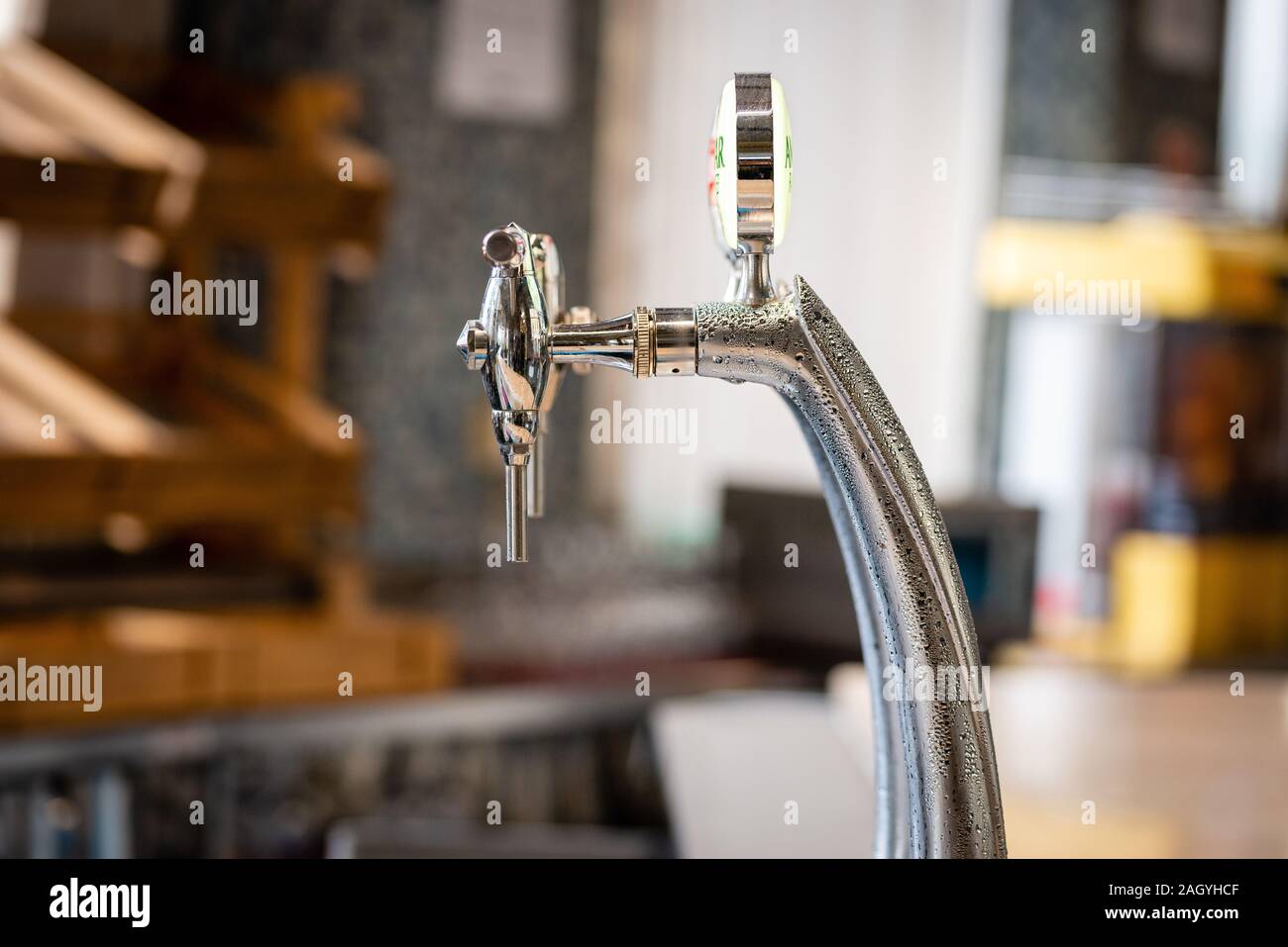 Close-up of shiny beer tap over unfocused background at brewery bar. Stock Photo